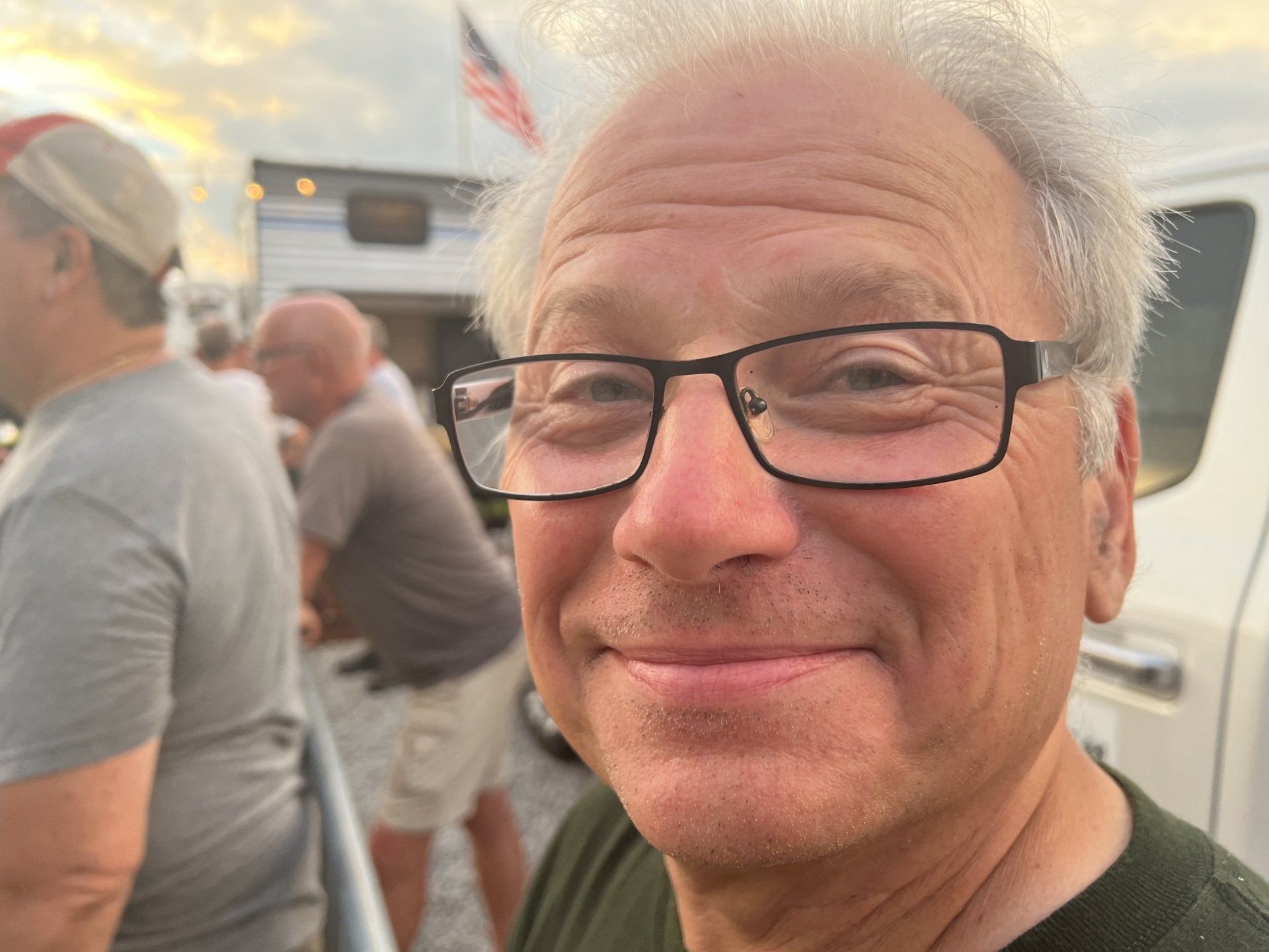 A man wearing glasses is smiling for the camera.