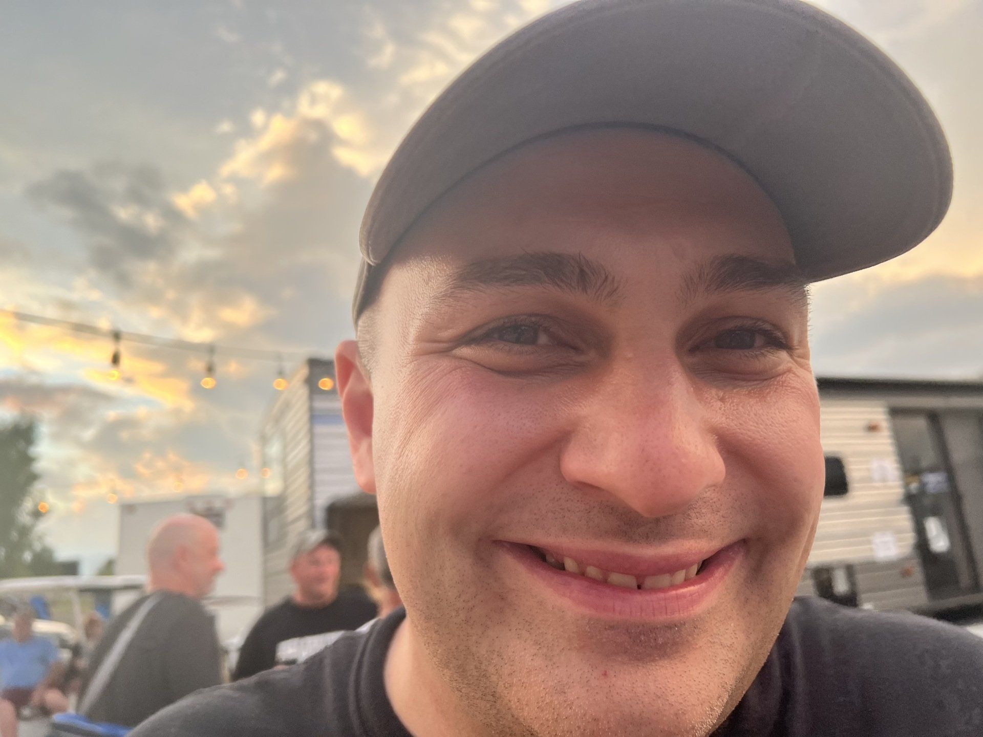 A man wearing a black hat is smiling for the camera.