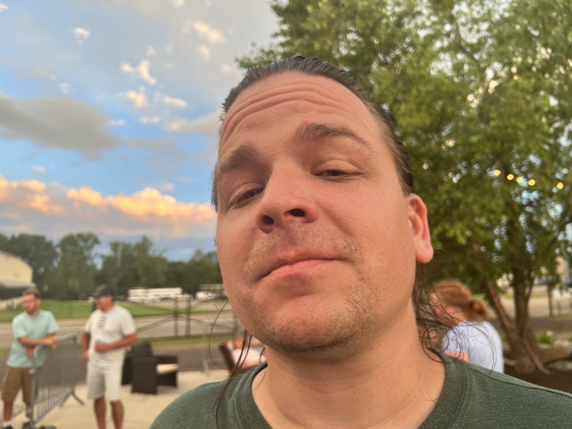 A man in a green shirt is making a funny face