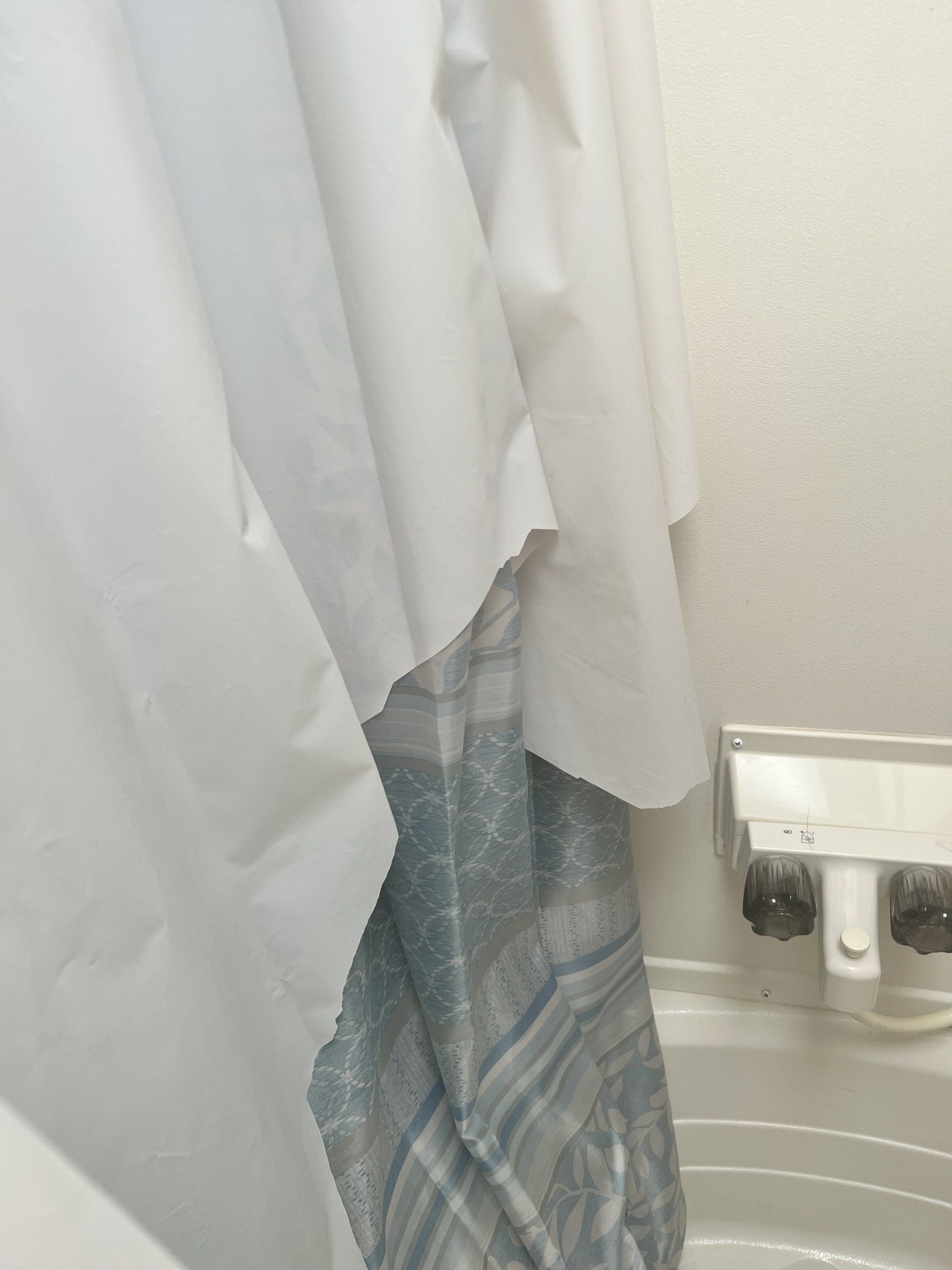 A shower curtain is hanging over a bathtub in a bathroom.
