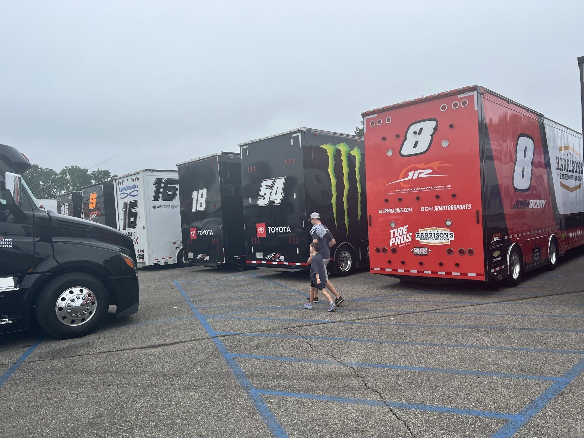 A row of race cars are parked in a parking lot
