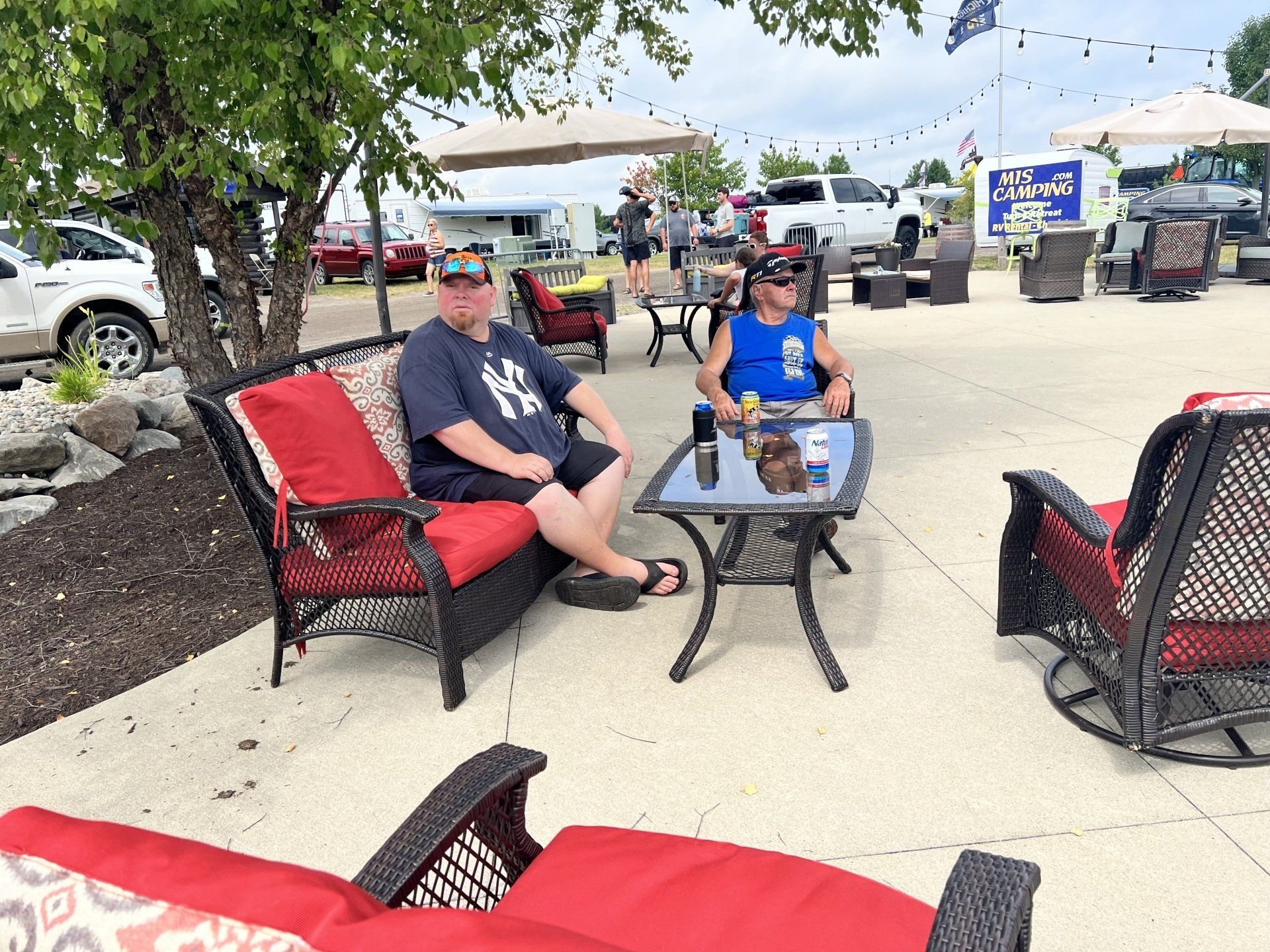 Two men are sitting at a table with a ny yankees shirt on