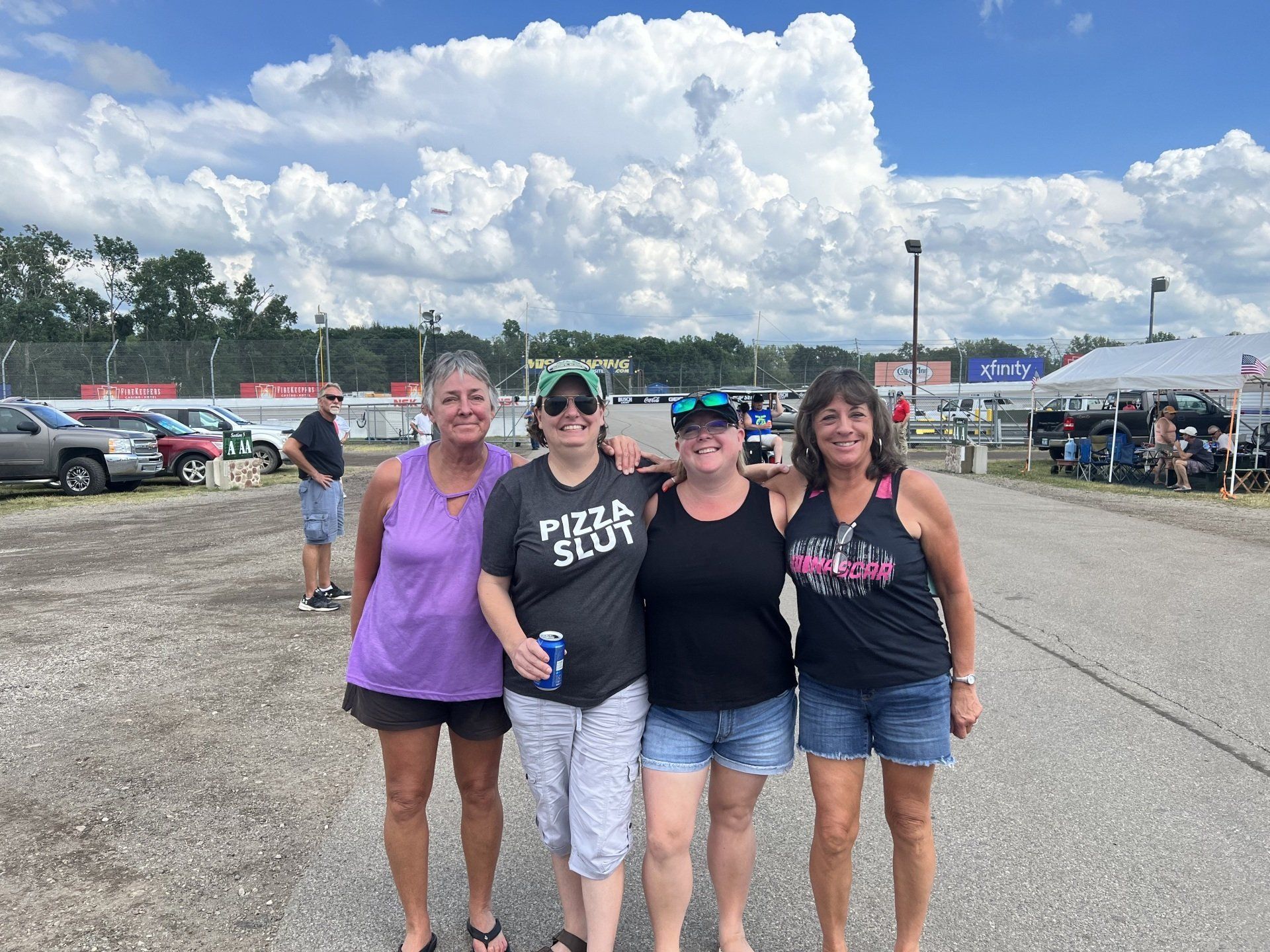A group of women are posing for a picture in a parking lot.