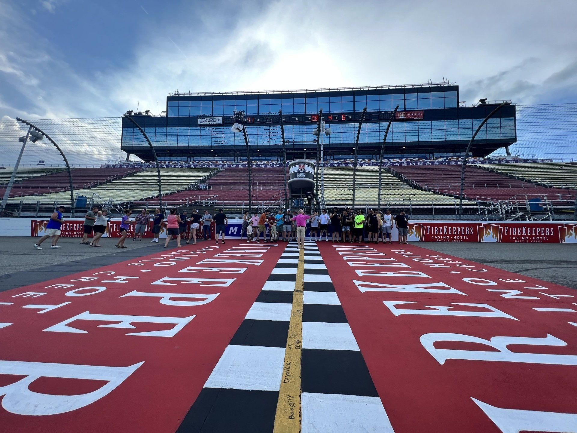A race track with a checkered finish line and a large building in the background
