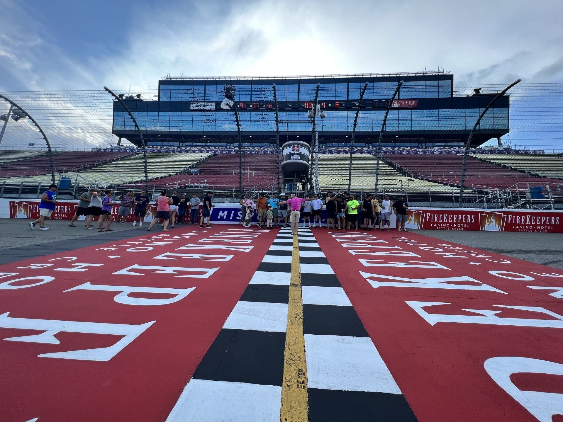 A race track with a checkered finish line and a large building in the background