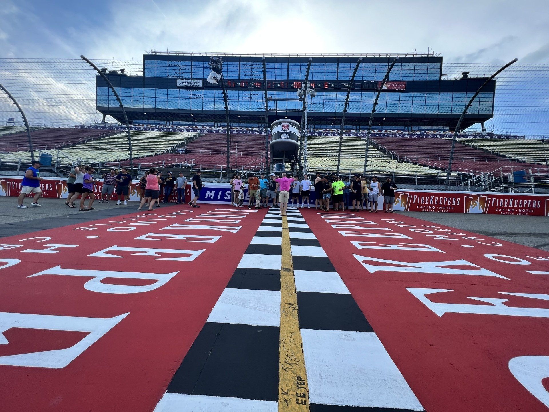 A race track with a checkered finish line and a large building in the background