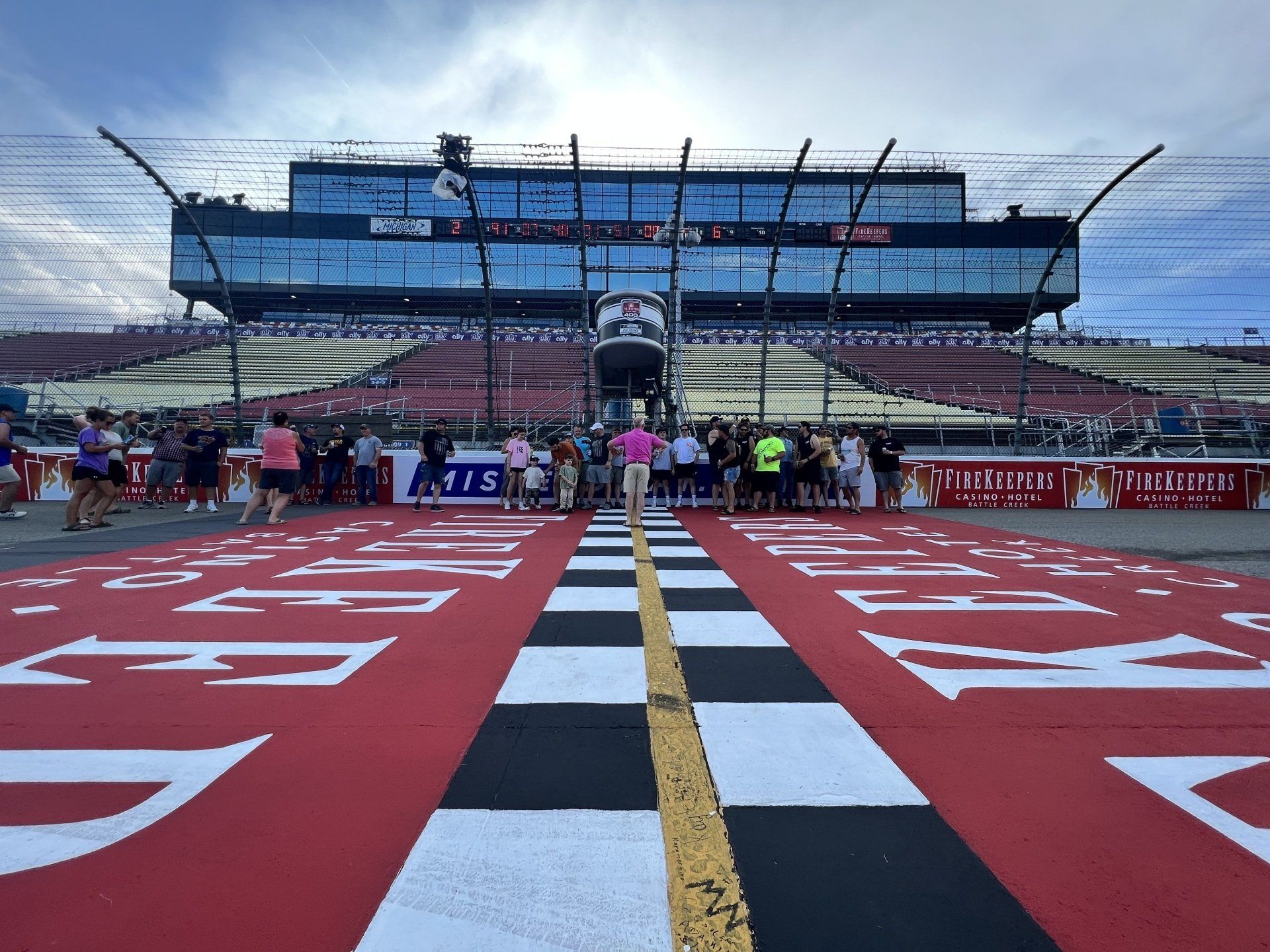 A race track with a checkered finish line and a large building in the background
