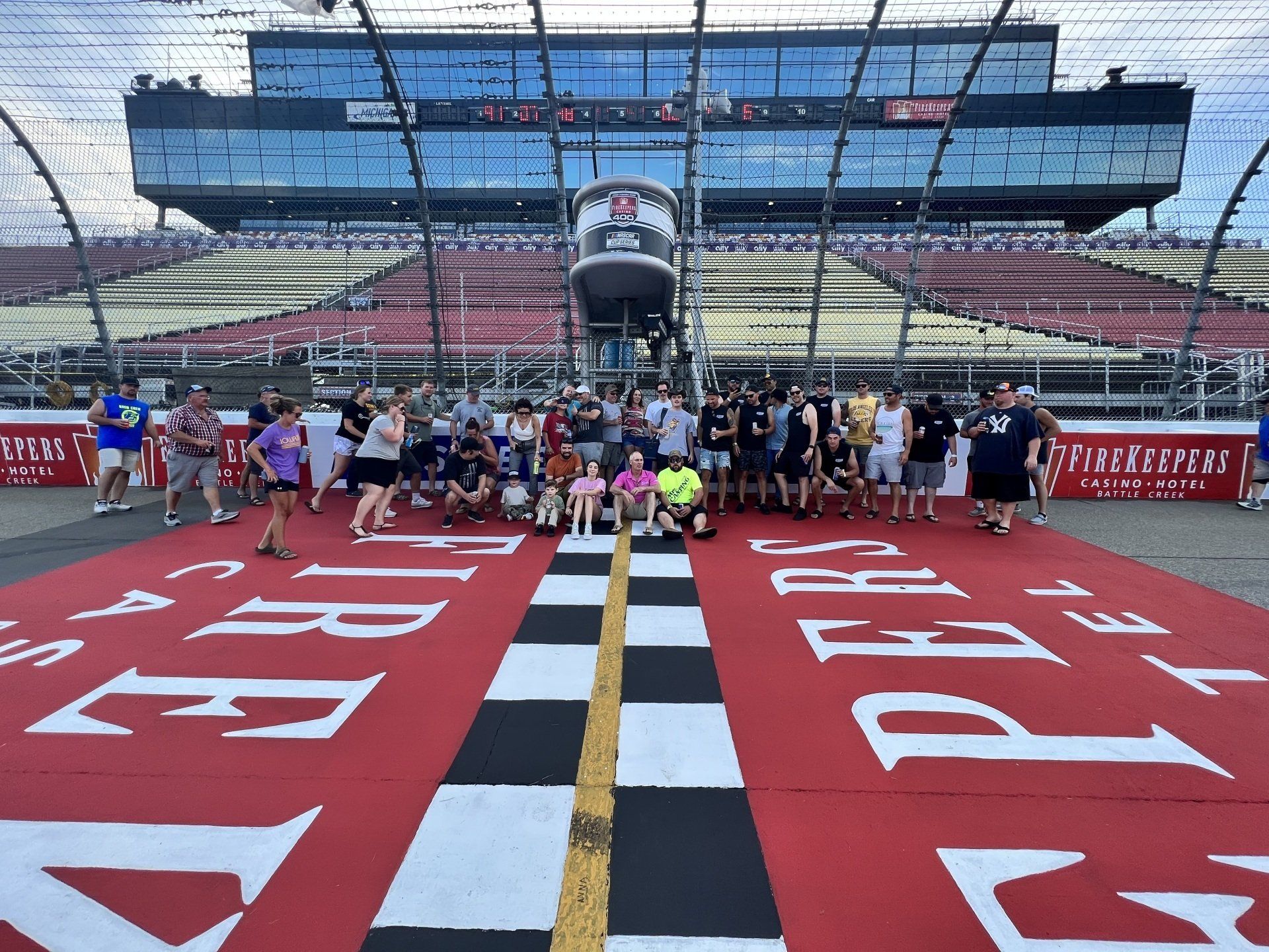 A group of people are posing for a picture in front of a race track
