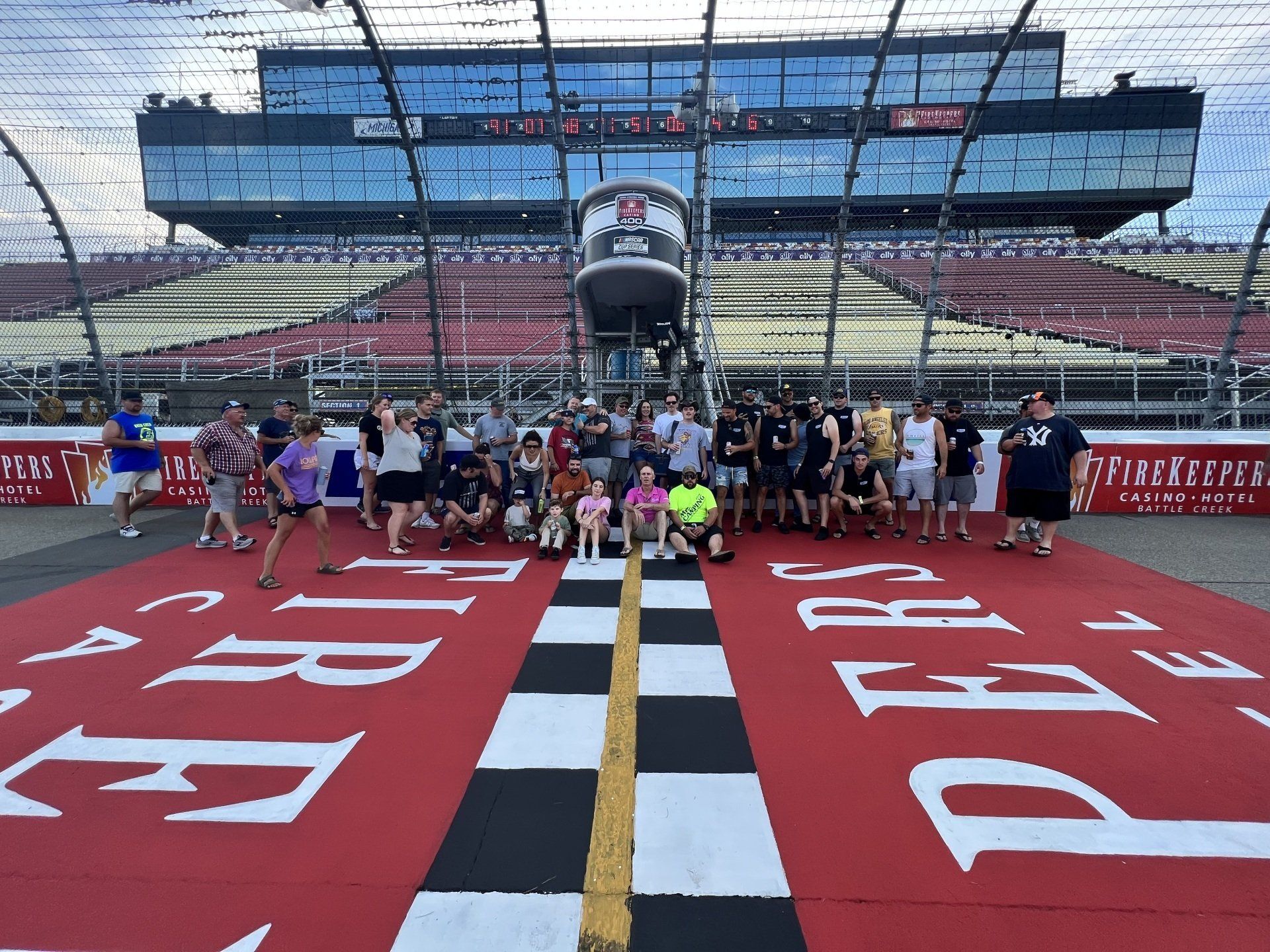 A group of people are posing for a picture on a race track
