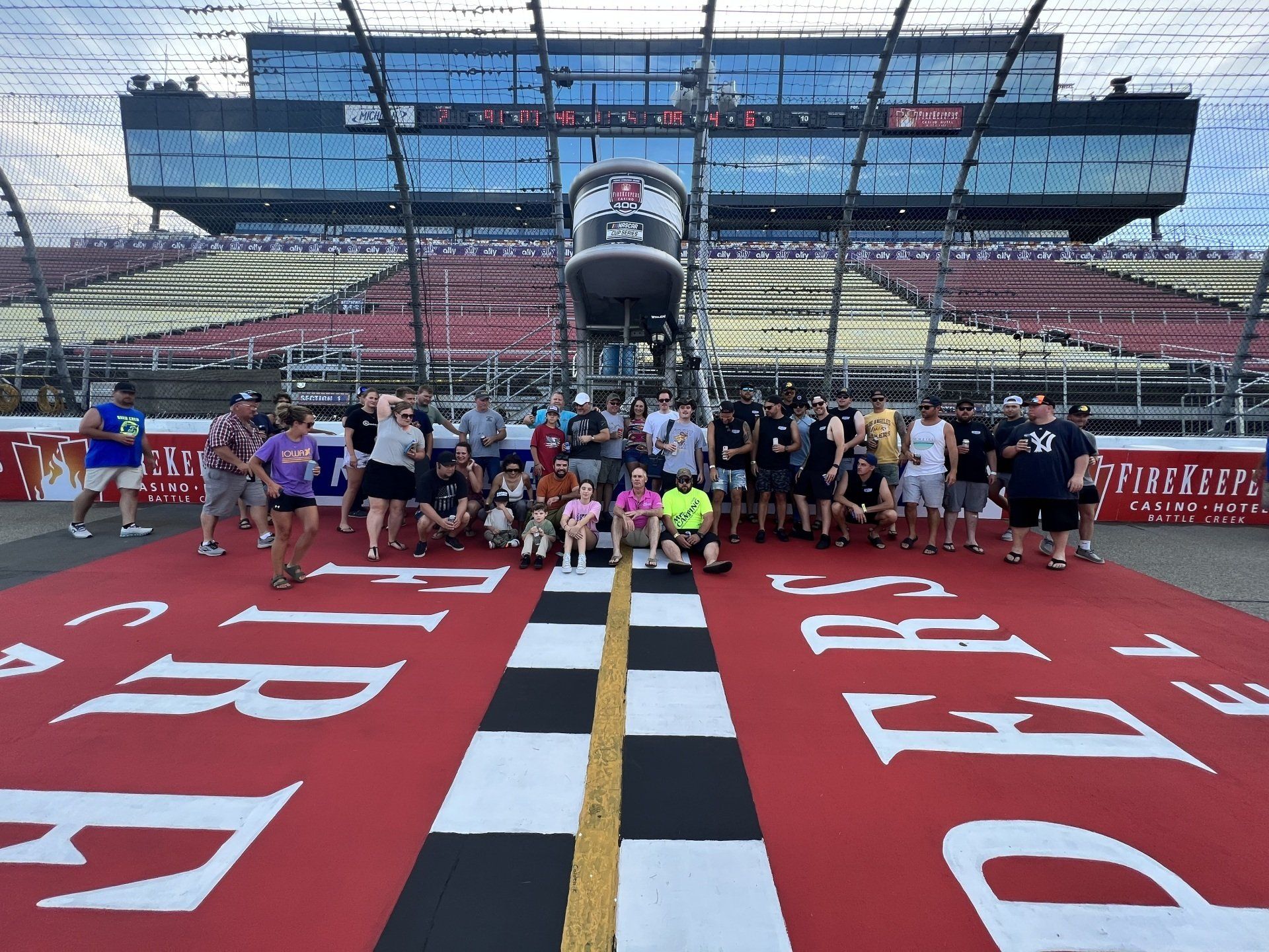 A group of people are posing for a picture on a race track