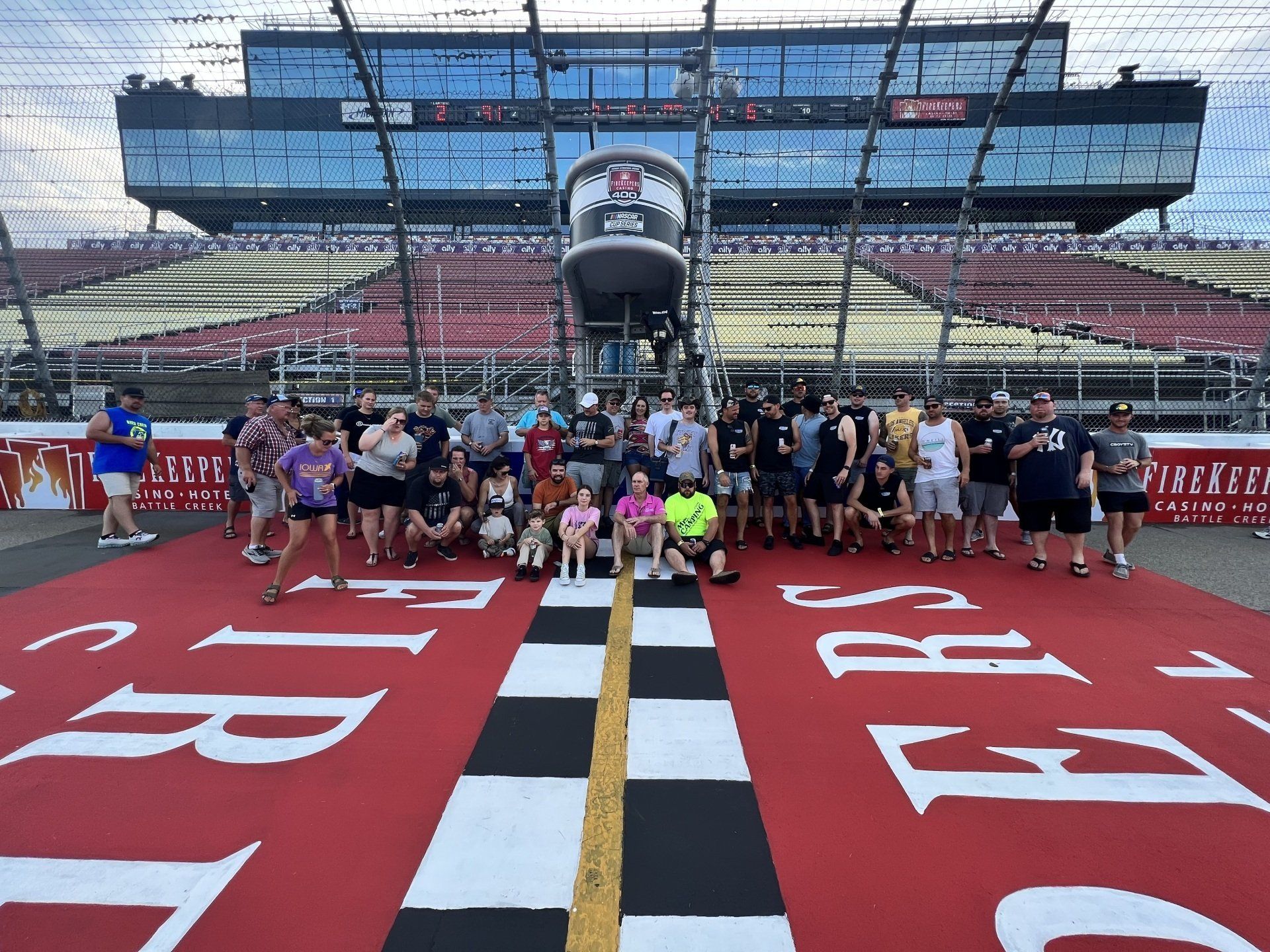 A group of people are posing for a picture on a race track