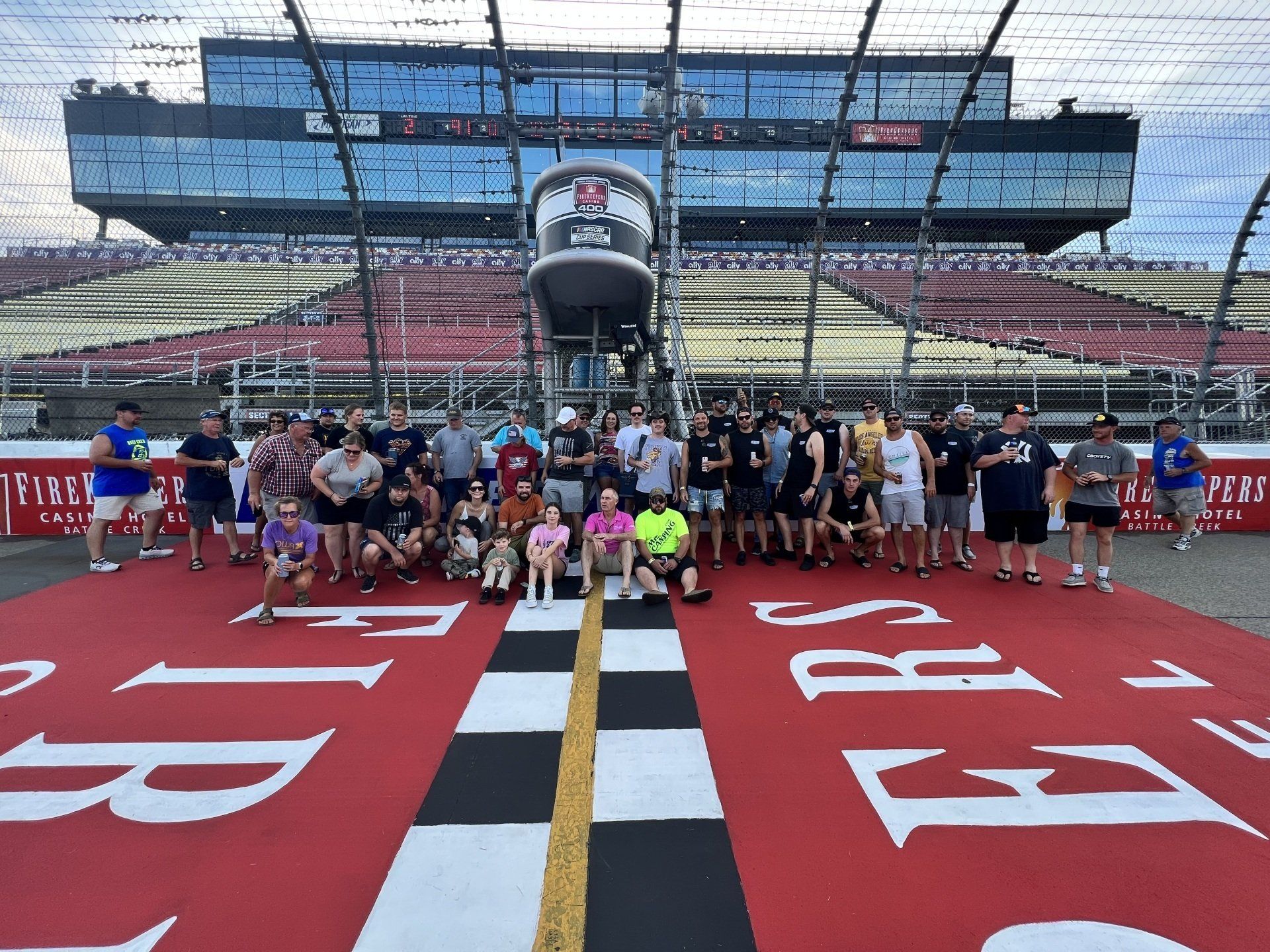 A group of people are posing for a picture on a race track
