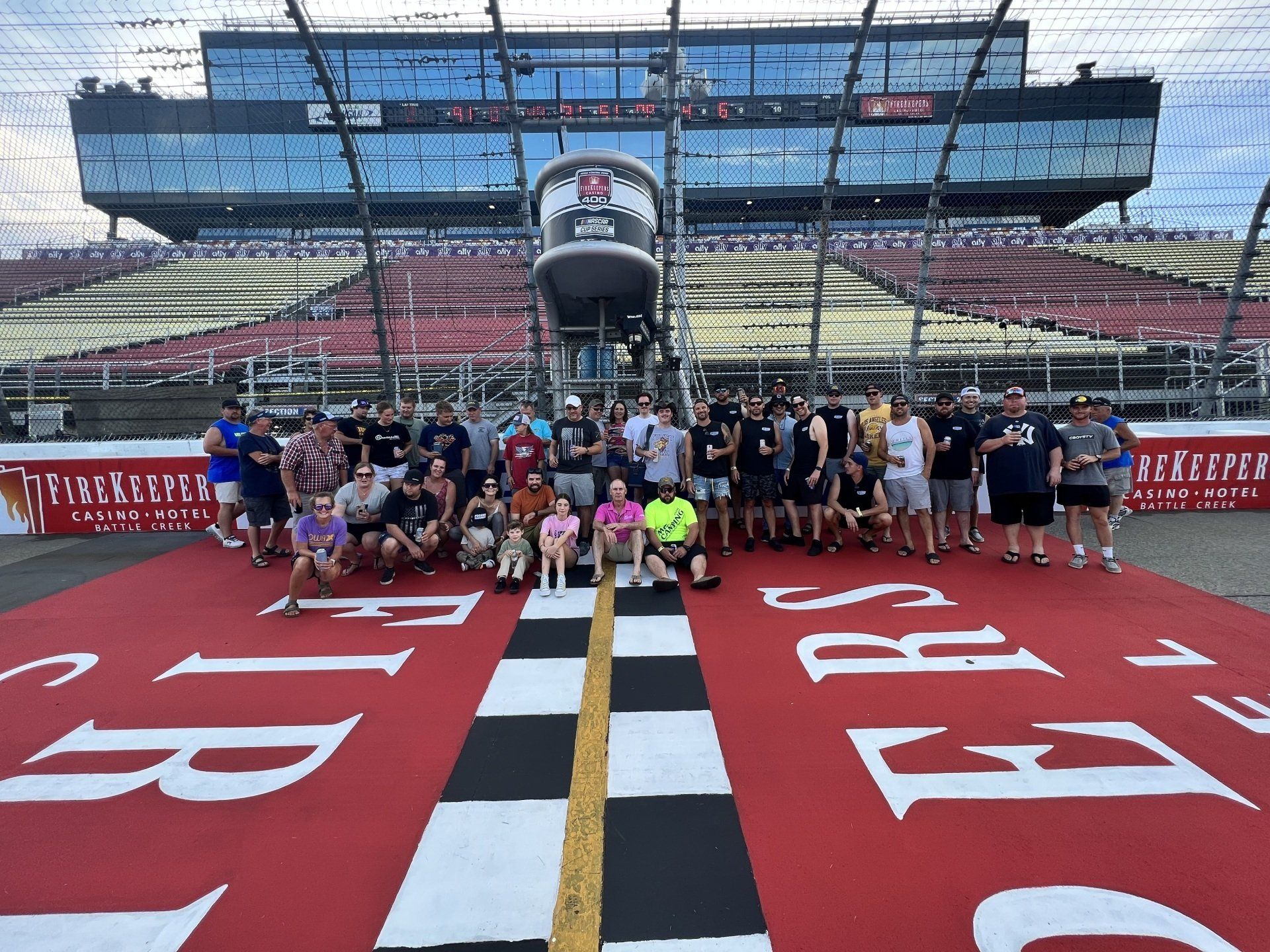 A group of people are posing for a picture in front of a race track