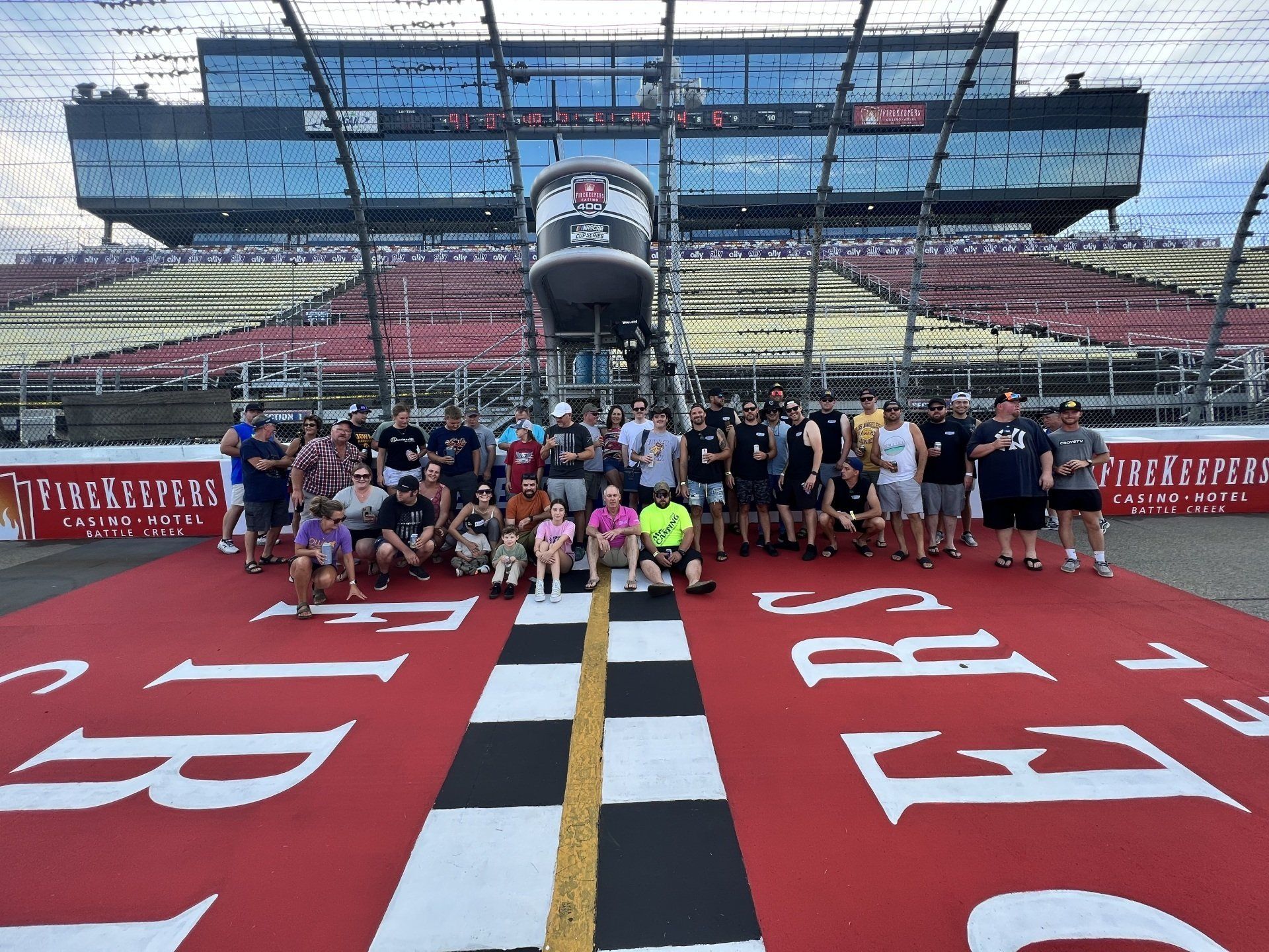 A group of people are posing for a picture in front of a race track