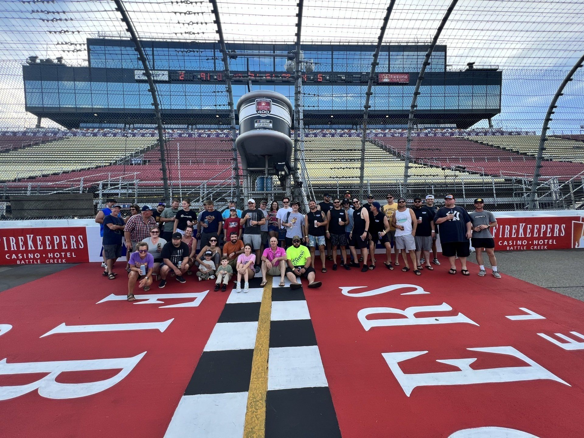 A group of people are posing for a picture in front of a race track