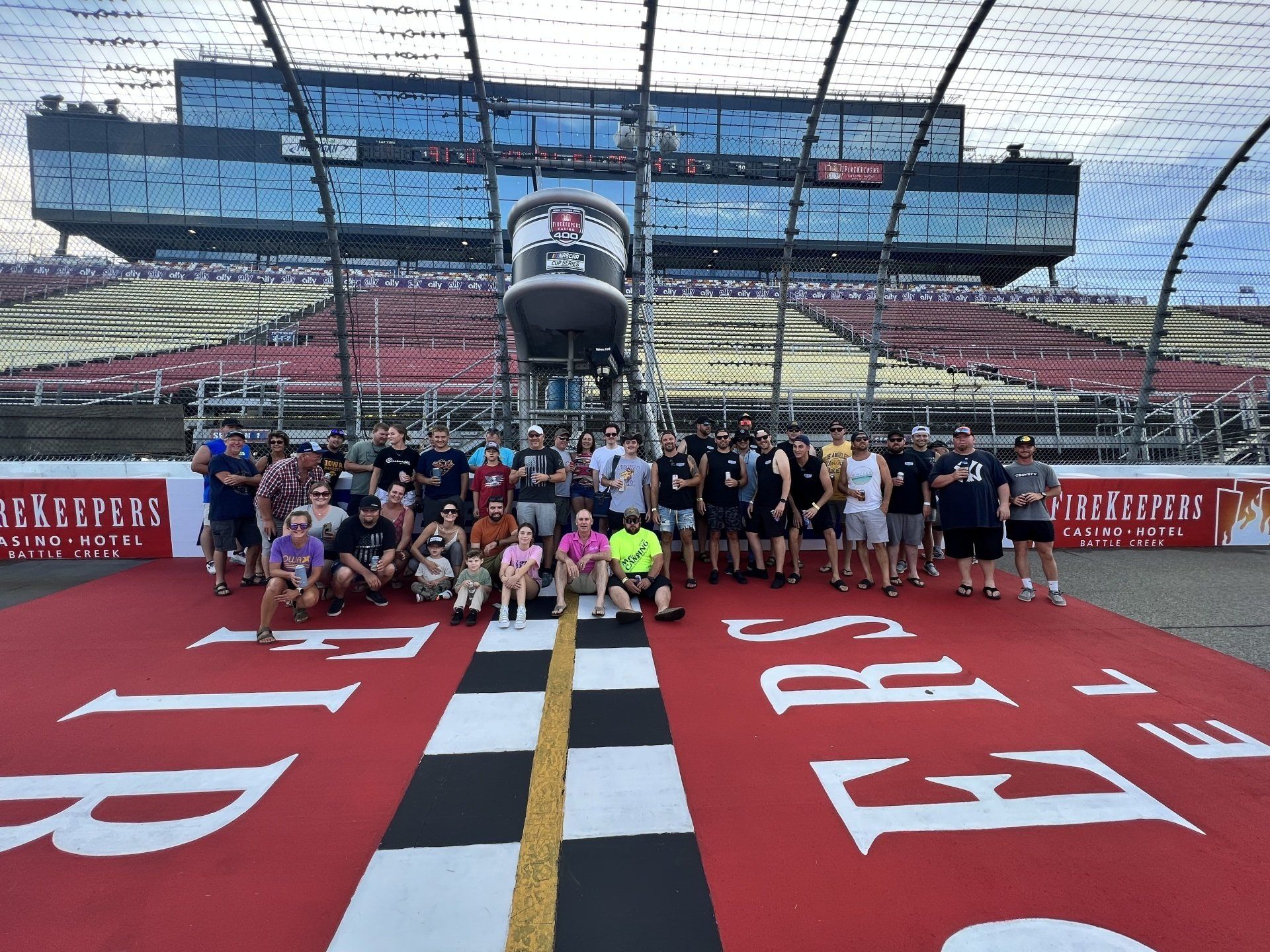 A group of people are posing for a picture on a race track