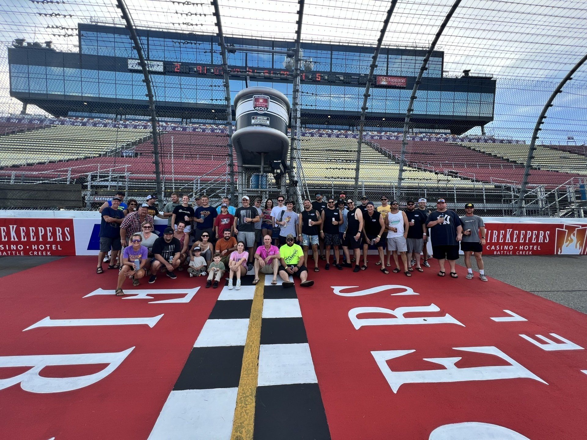 A group of people are posing for a picture on a race track