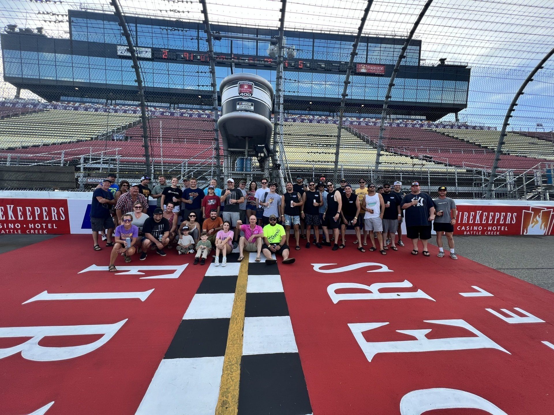 A group of people are posing for a picture in front of a race track