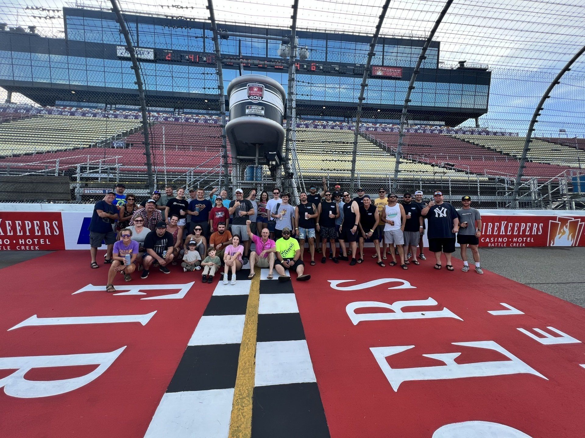 A group of people are posing for a picture on a race track