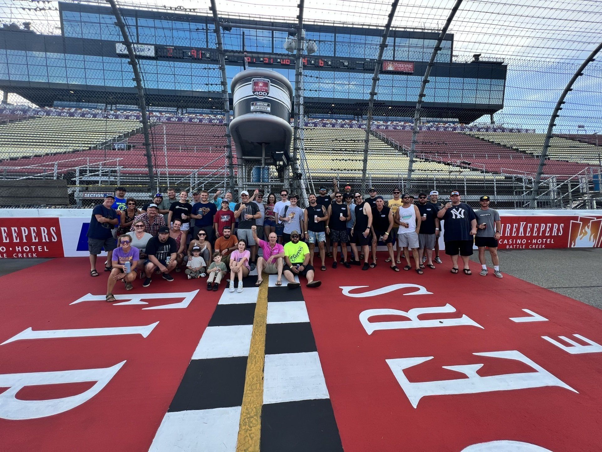 A group of people are posing for a picture on a race track.