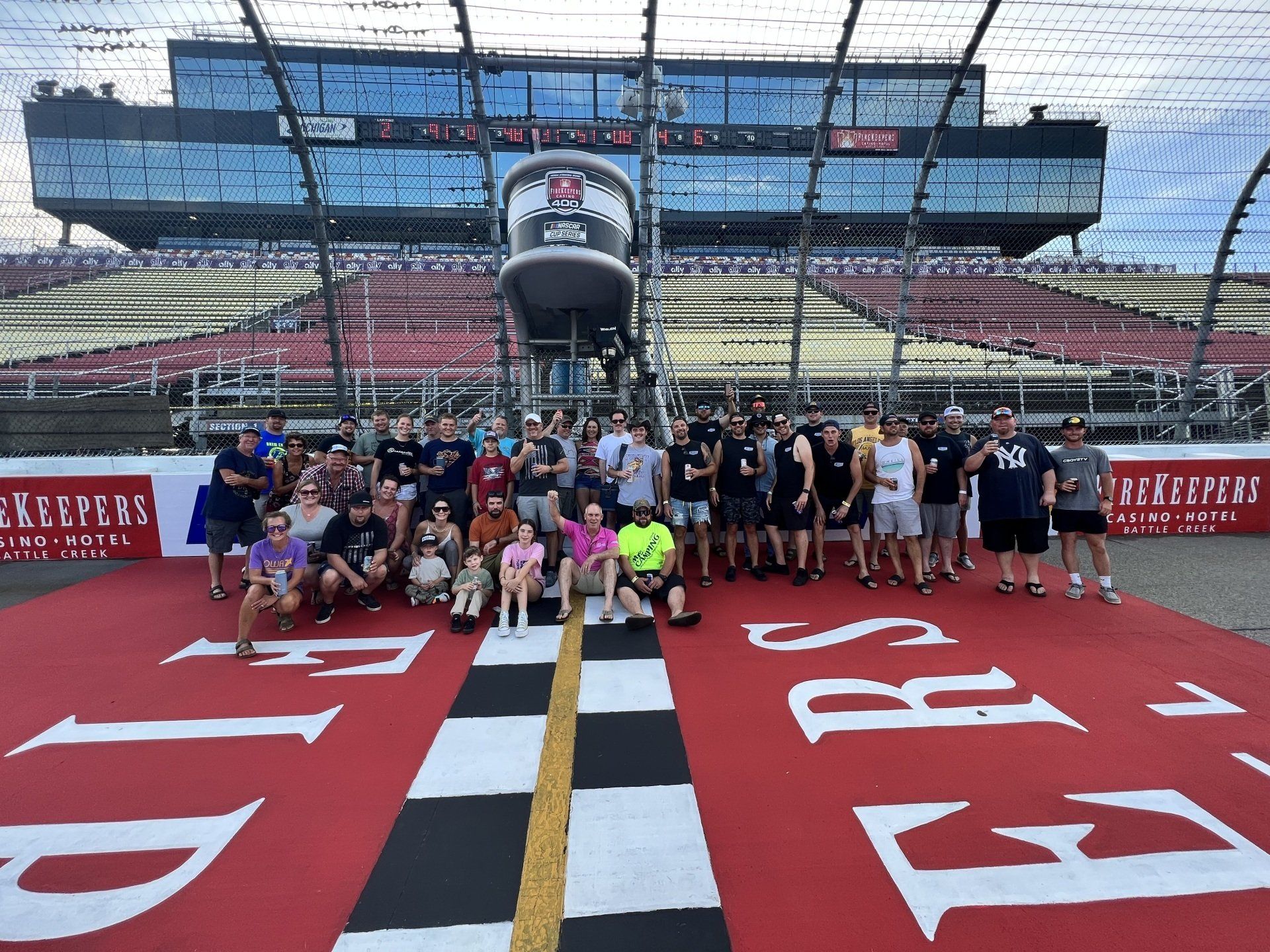 A group of people are posing for a picture in front of a race track