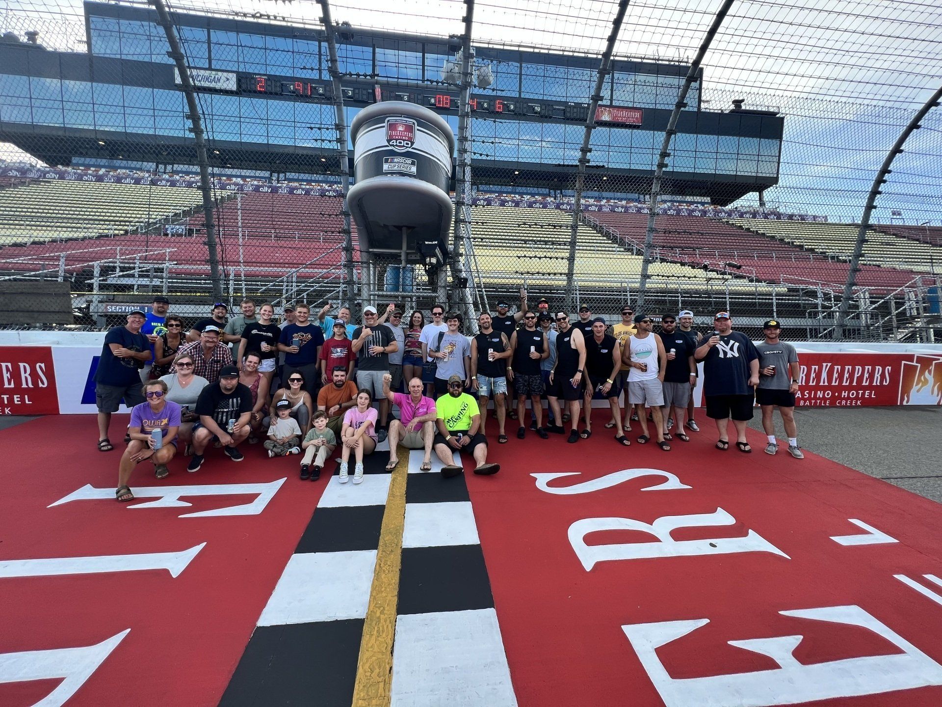 A group of people are posing for a picture at a race track