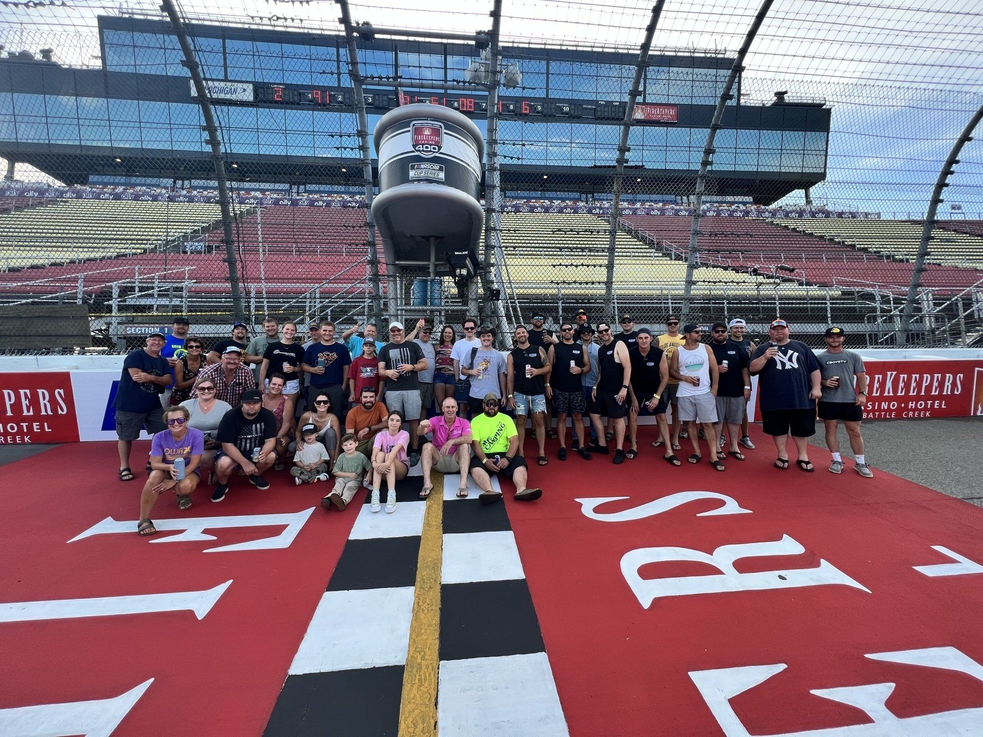 A group of people are posing for a picture in front of a race track