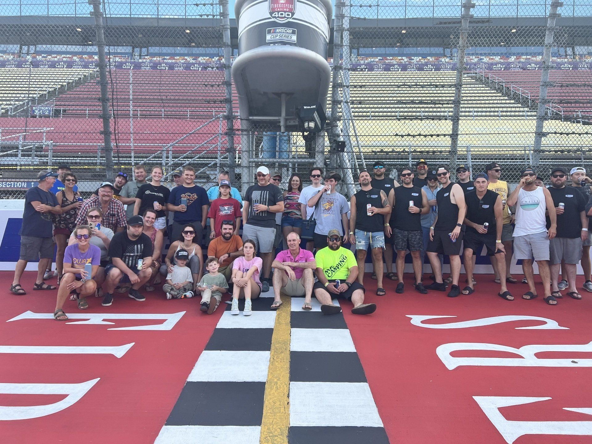 A group of people are posing for a picture in front of a sign that says indy 500