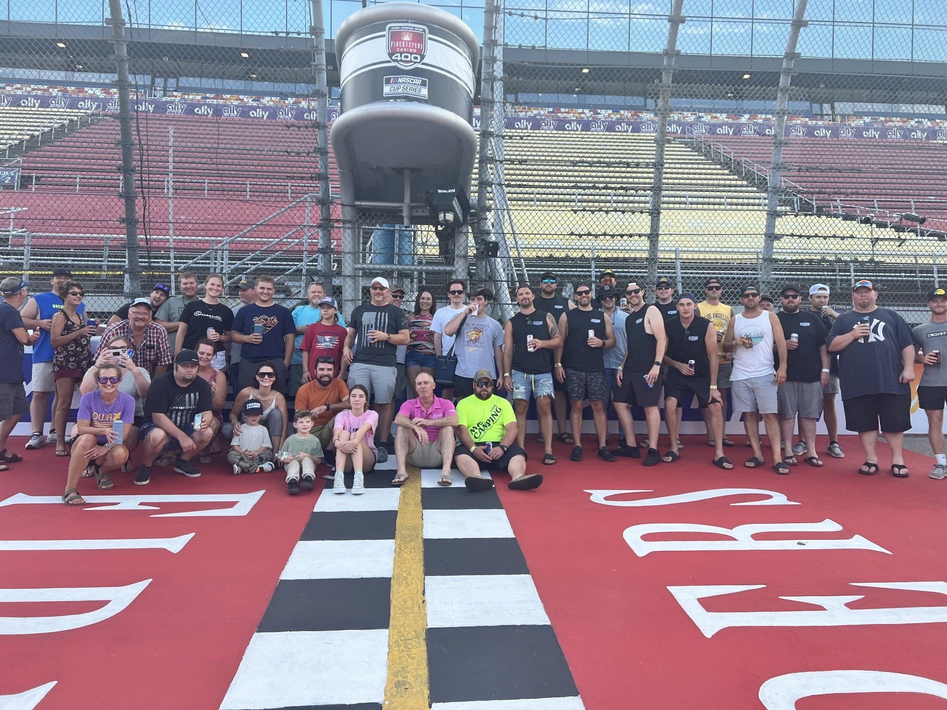 A group of people posing for a picture in front of a sign that says first