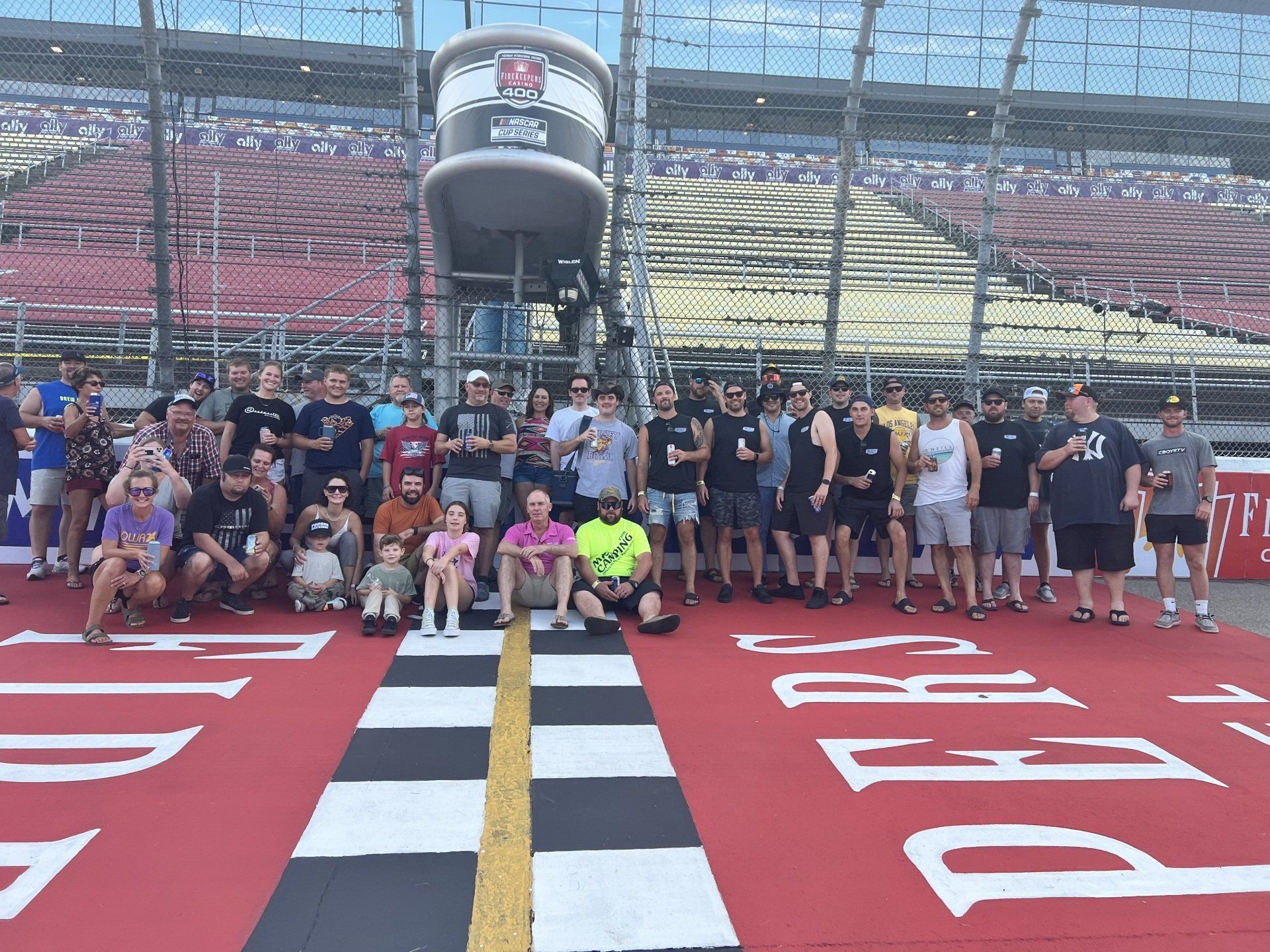 A group of people are posing for a picture on a race track