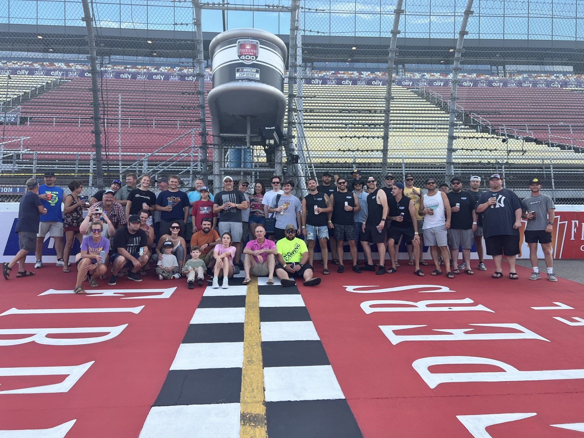 A group of people are posing for a picture at a race track