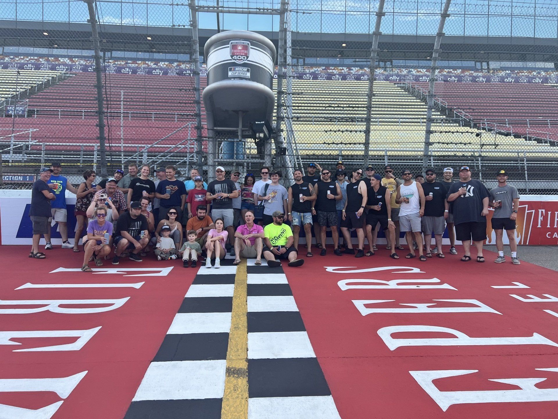 A group of people are posing for a picture on a race track