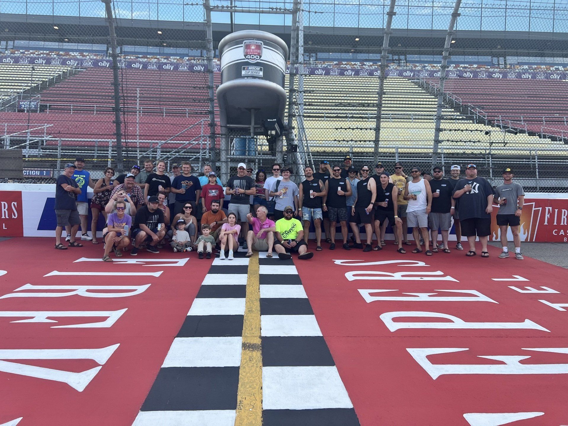 A group of people are posing for a picture at a race track