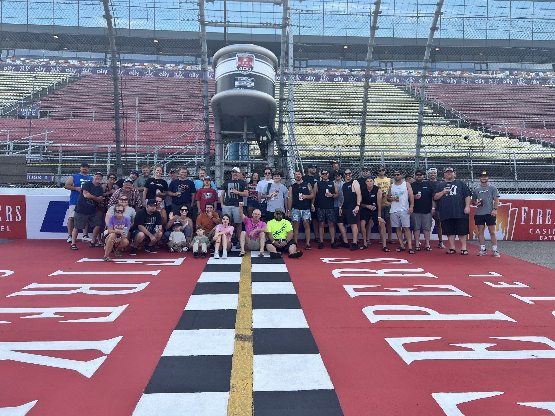 A group of people posing for a picture on a race track