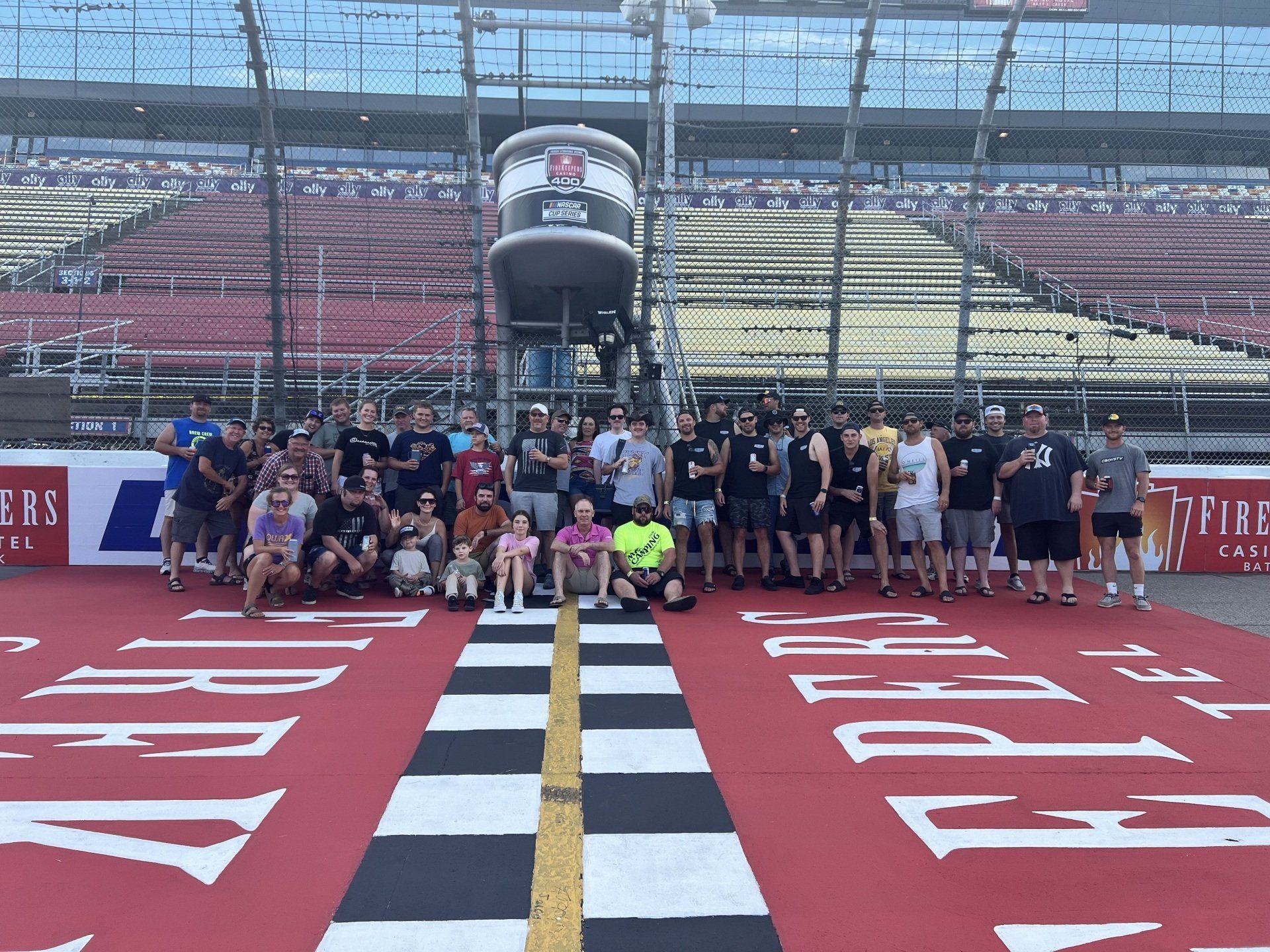 A group of people are posing for a picture on a race track
