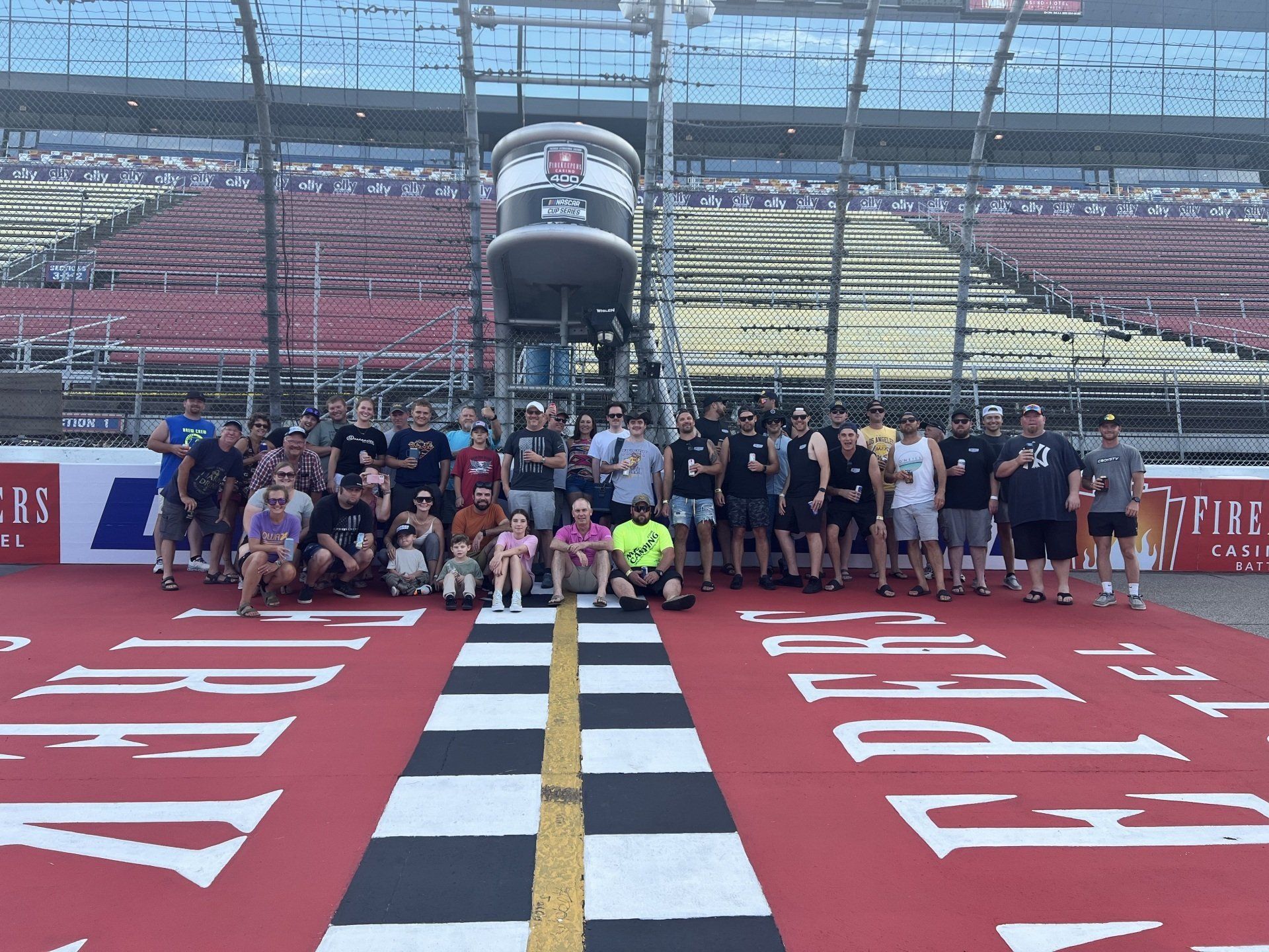 A group of people are posing for a picture on a race track