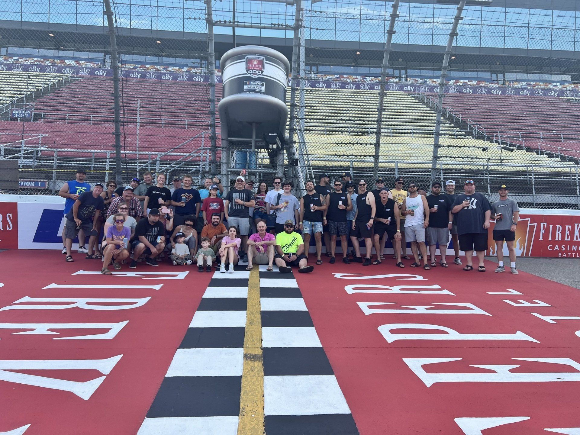 A group of people are posing for a picture on a race track