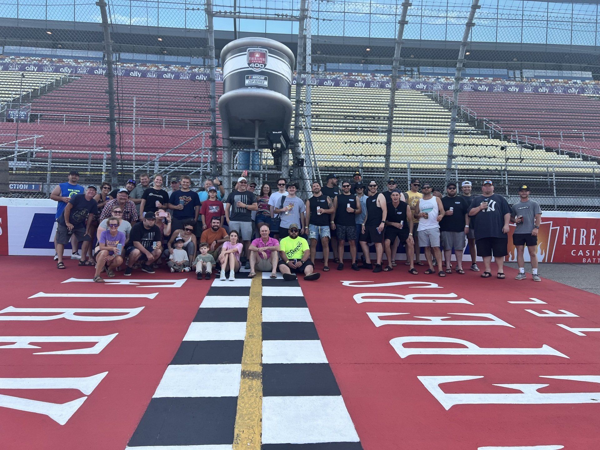 A group of people are posing for a picture on a race track