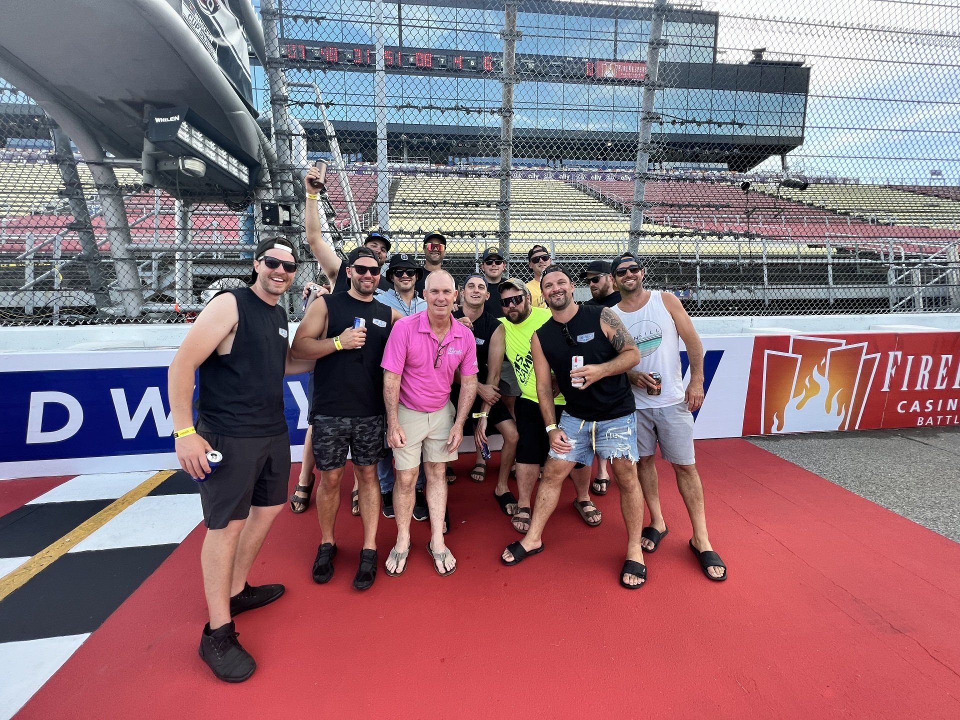 A group of men are posing for a picture in front of a dw sign