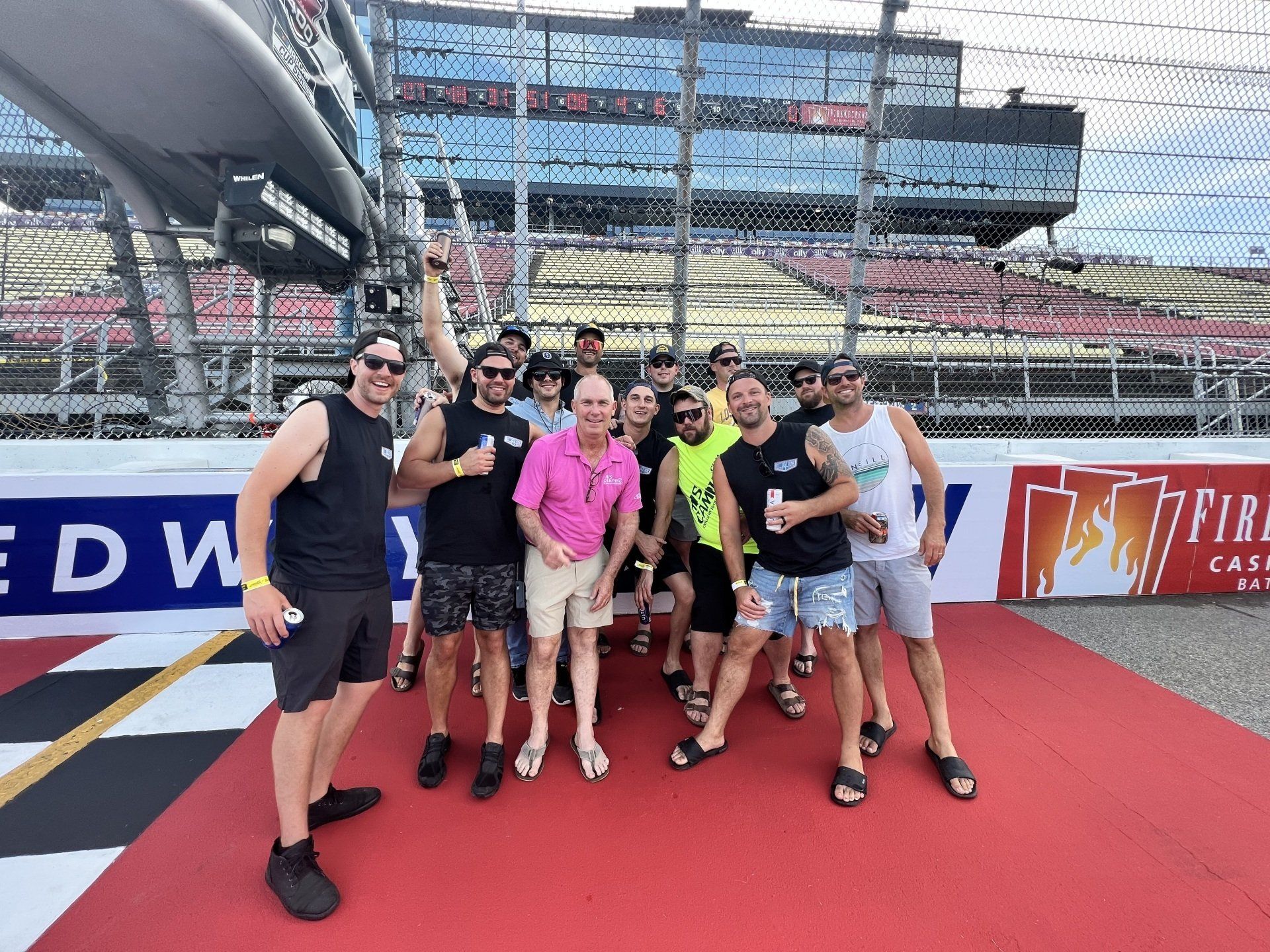 A group of men are posing for a picture in front of a sign that says fire