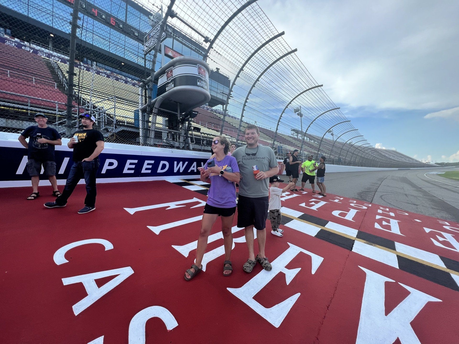 A man and a woman are standing on a race track.