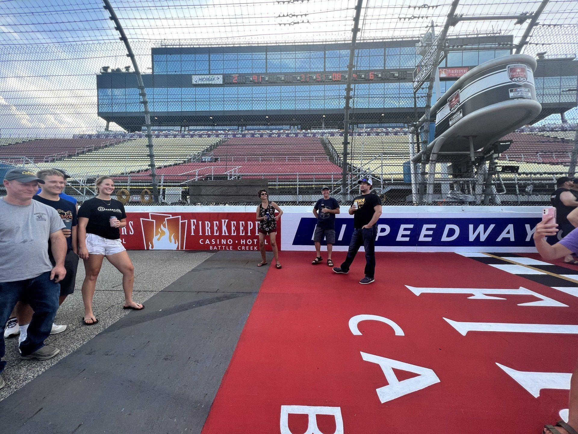 A group of people standing in front of a peedway sign