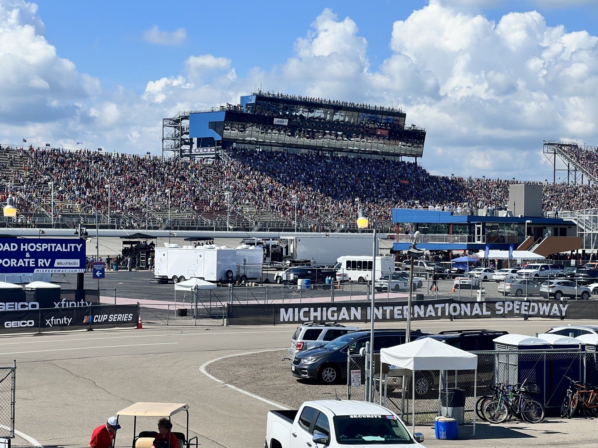 A large crowd is watching a race at the michigan international speedway