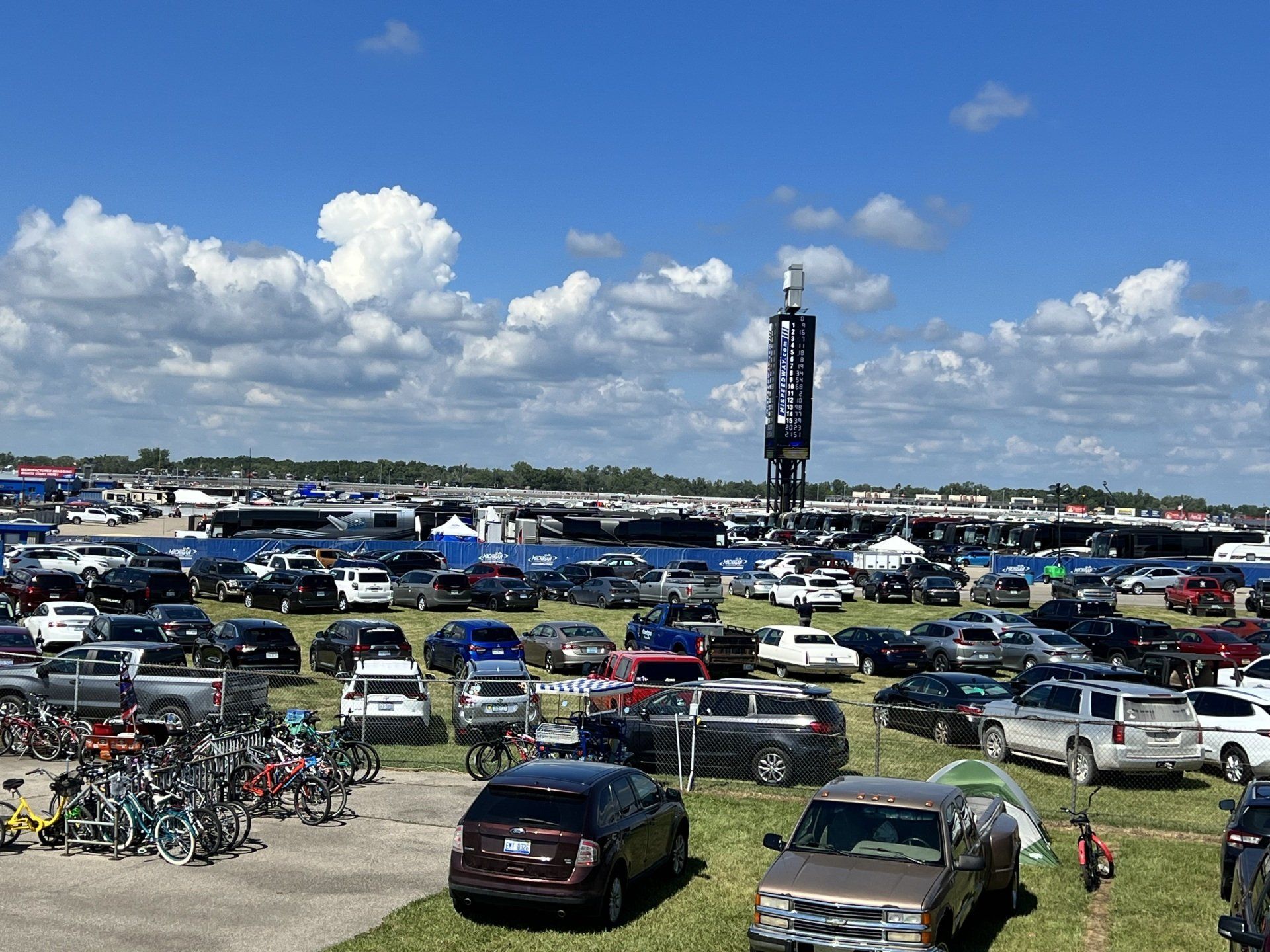 A lot of cars and bikes are parked in a parking lot.