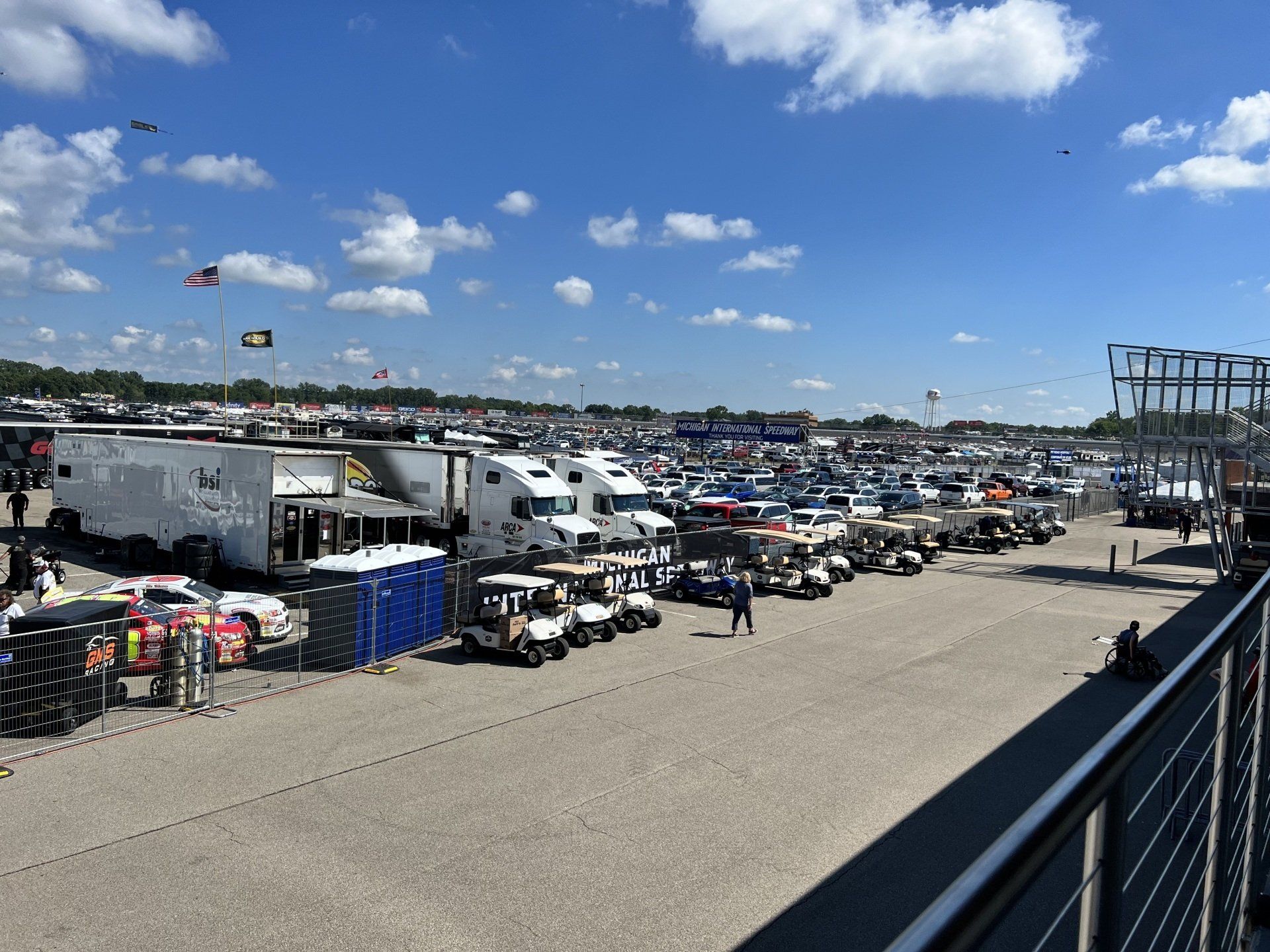 A lot of golf carts are parked in a parking lot