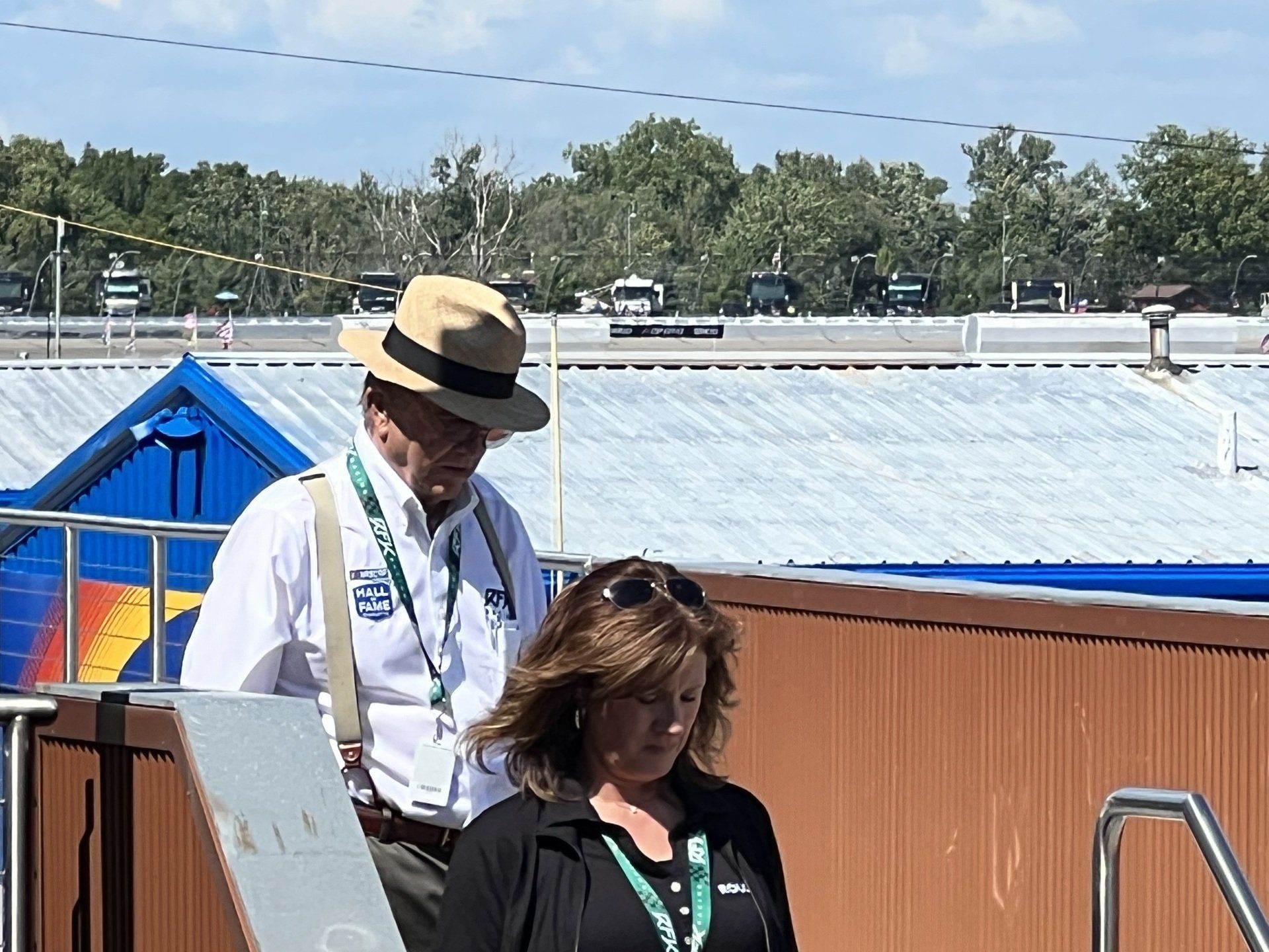A man in a hat stands next to a woman in a black jacket