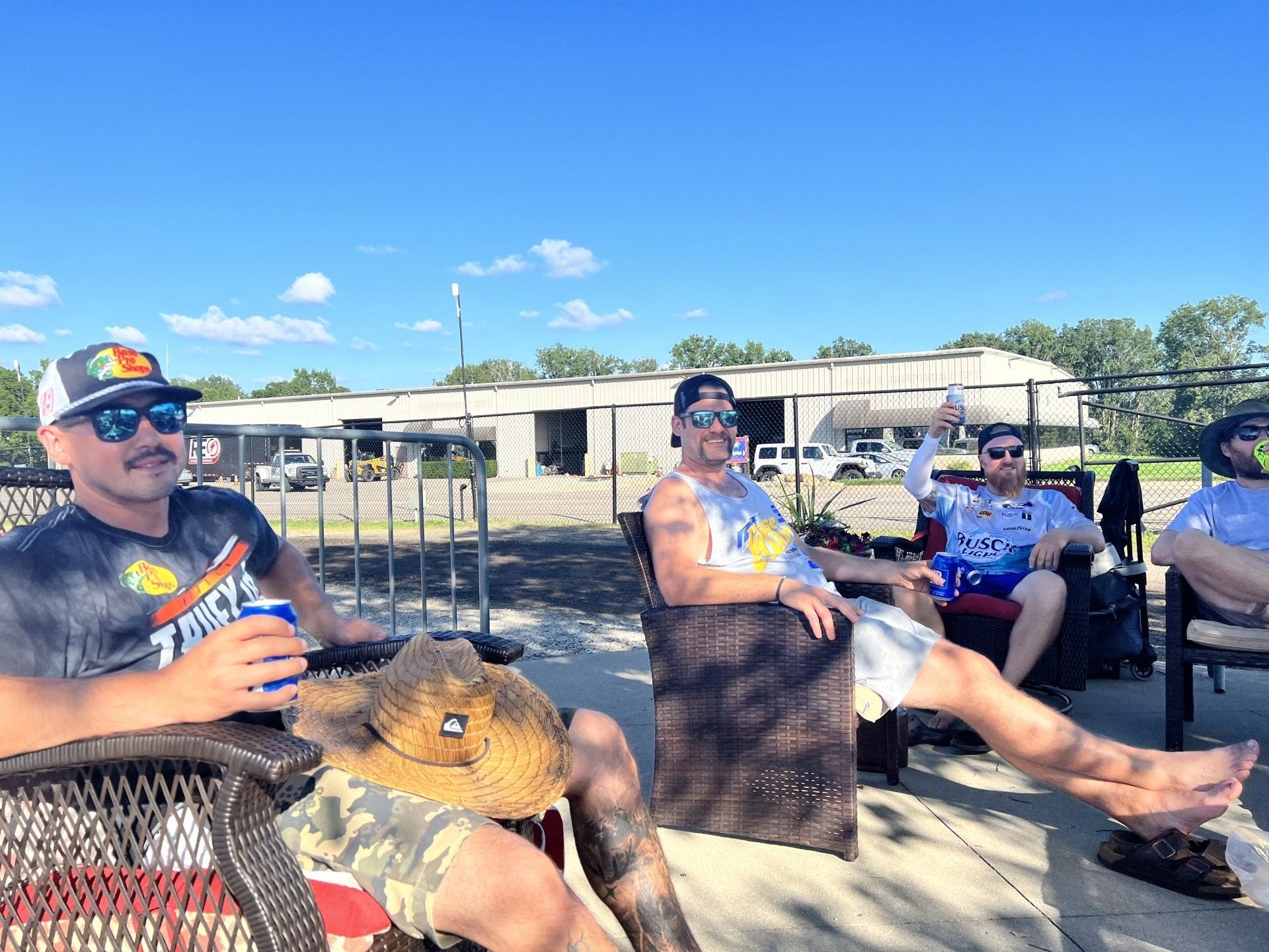 A group of men are sitting in chairs on a patio.