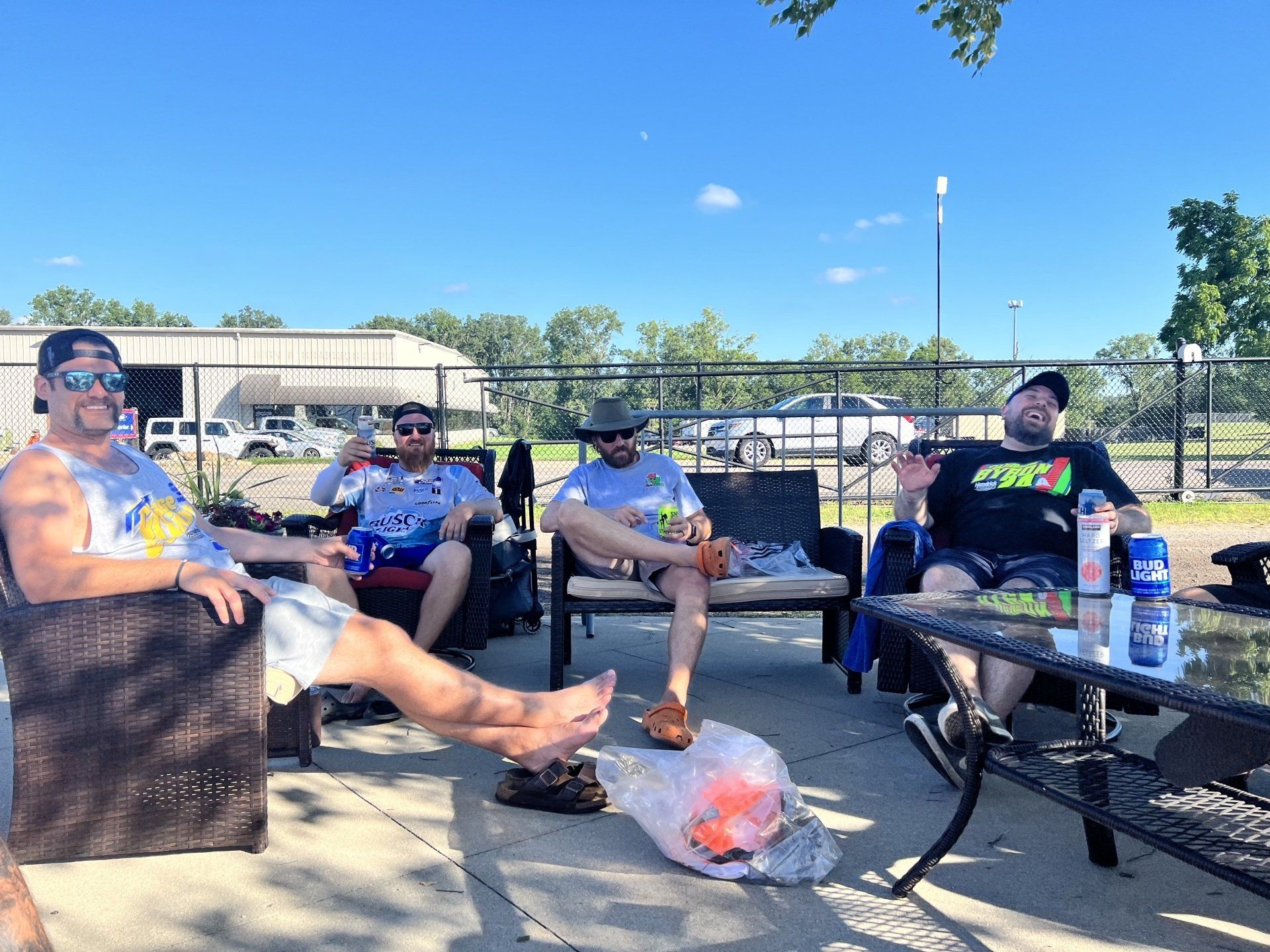 A group of men are sitting on a patio with their feet up