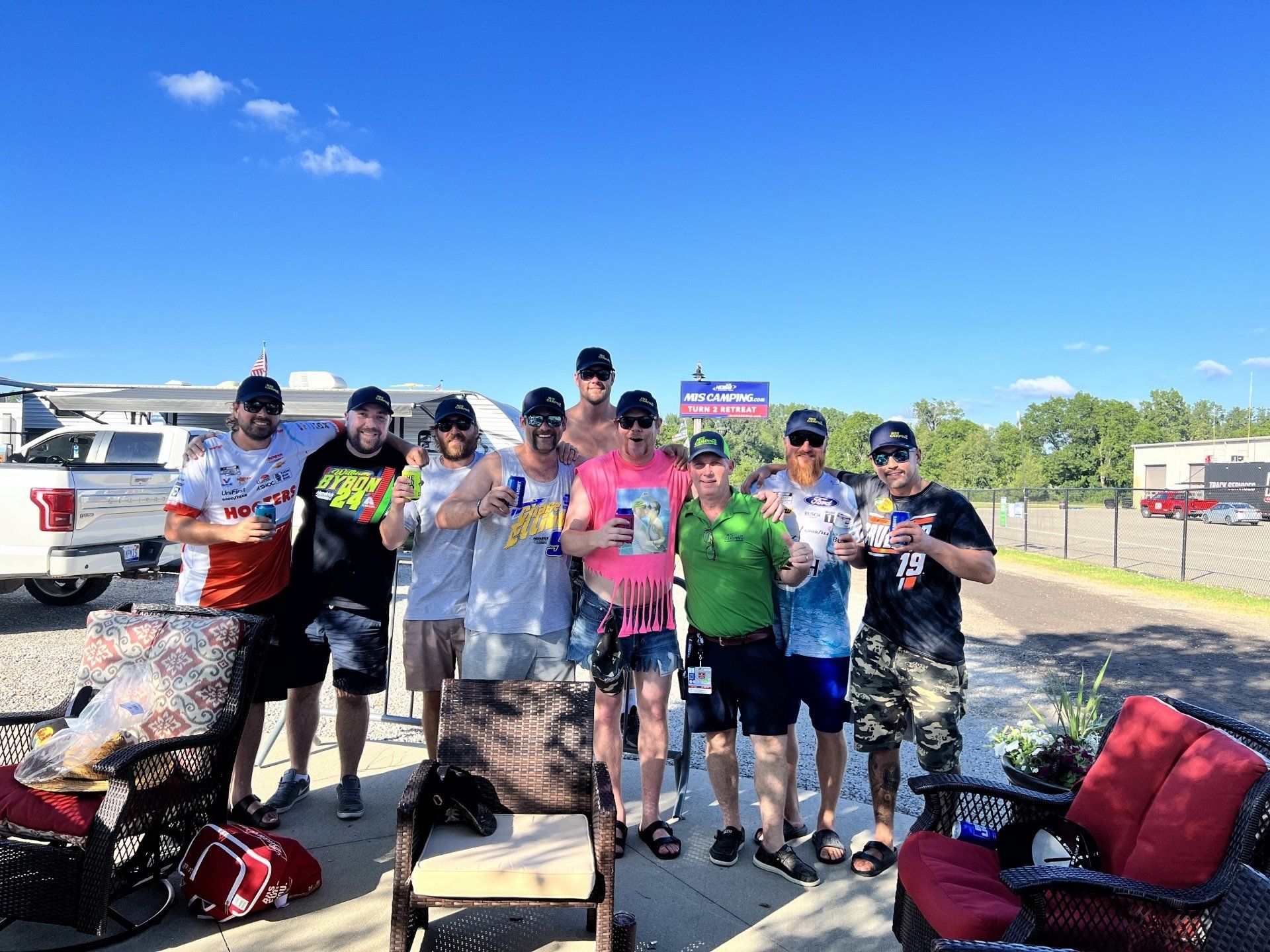 A group of people are posing for a picture in a parking lot.