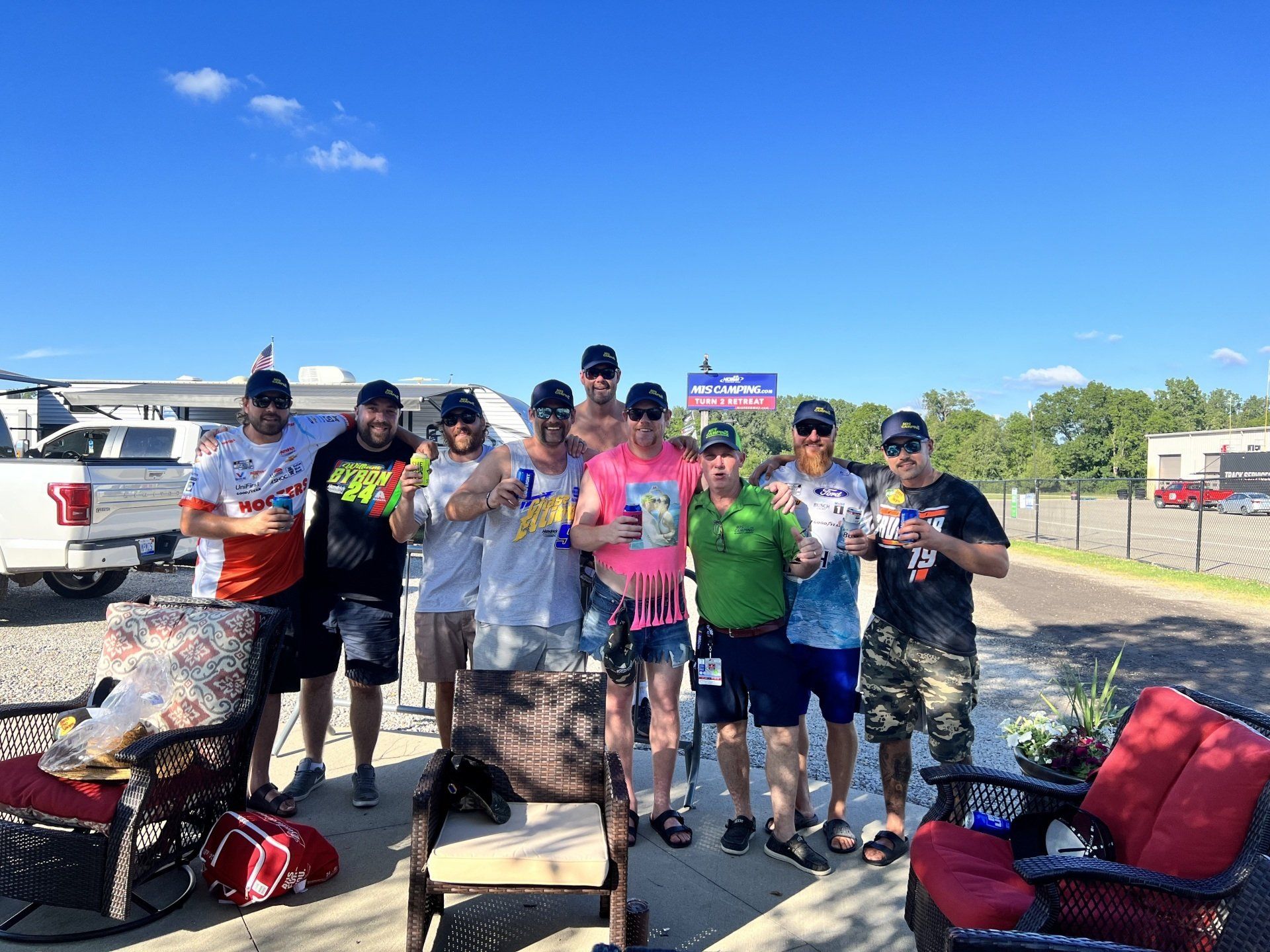 A group of people are posing for a picture in a parking lot.